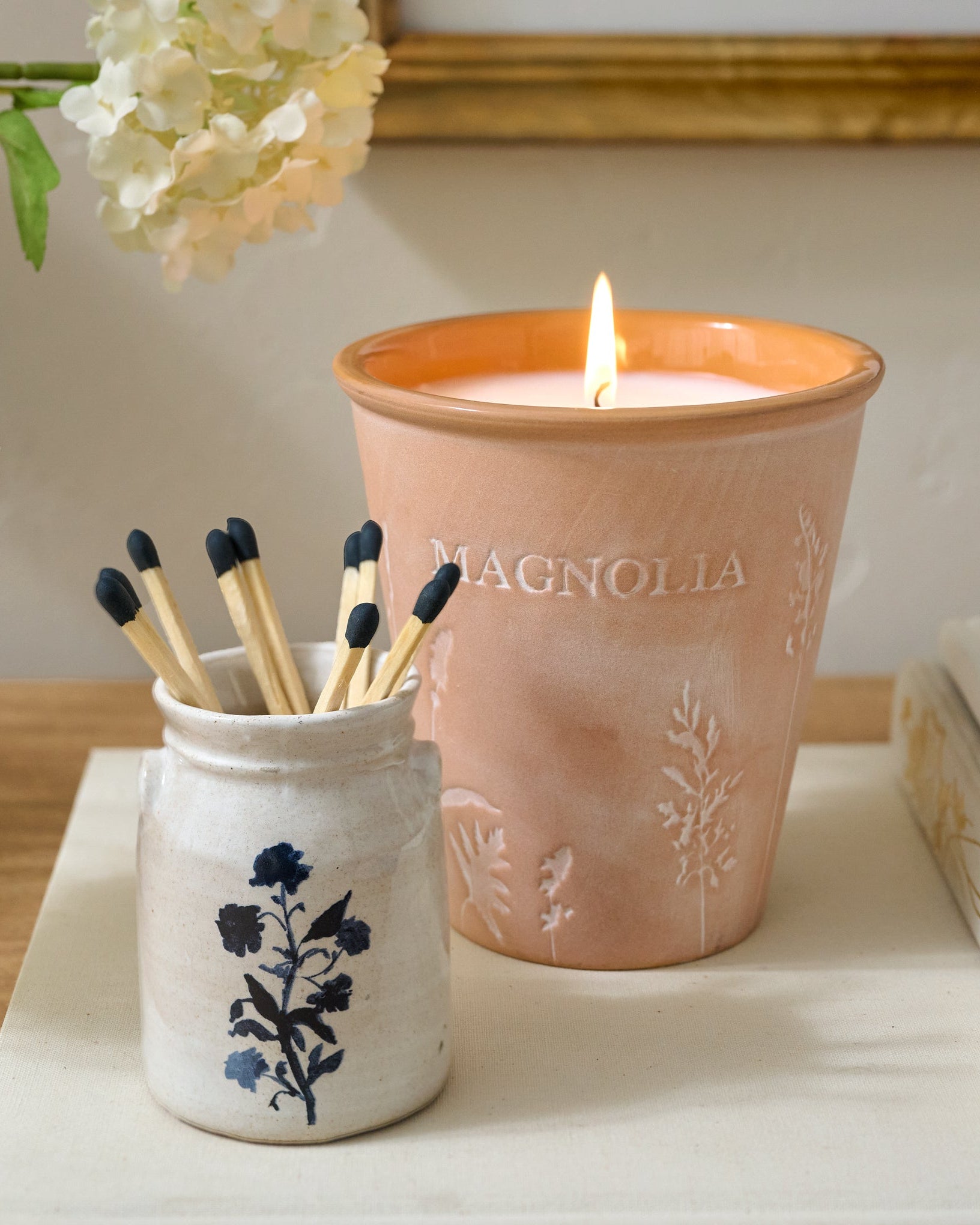 Magnoliass Basil Orange Garden Pot Candle shown with matches and mini crock