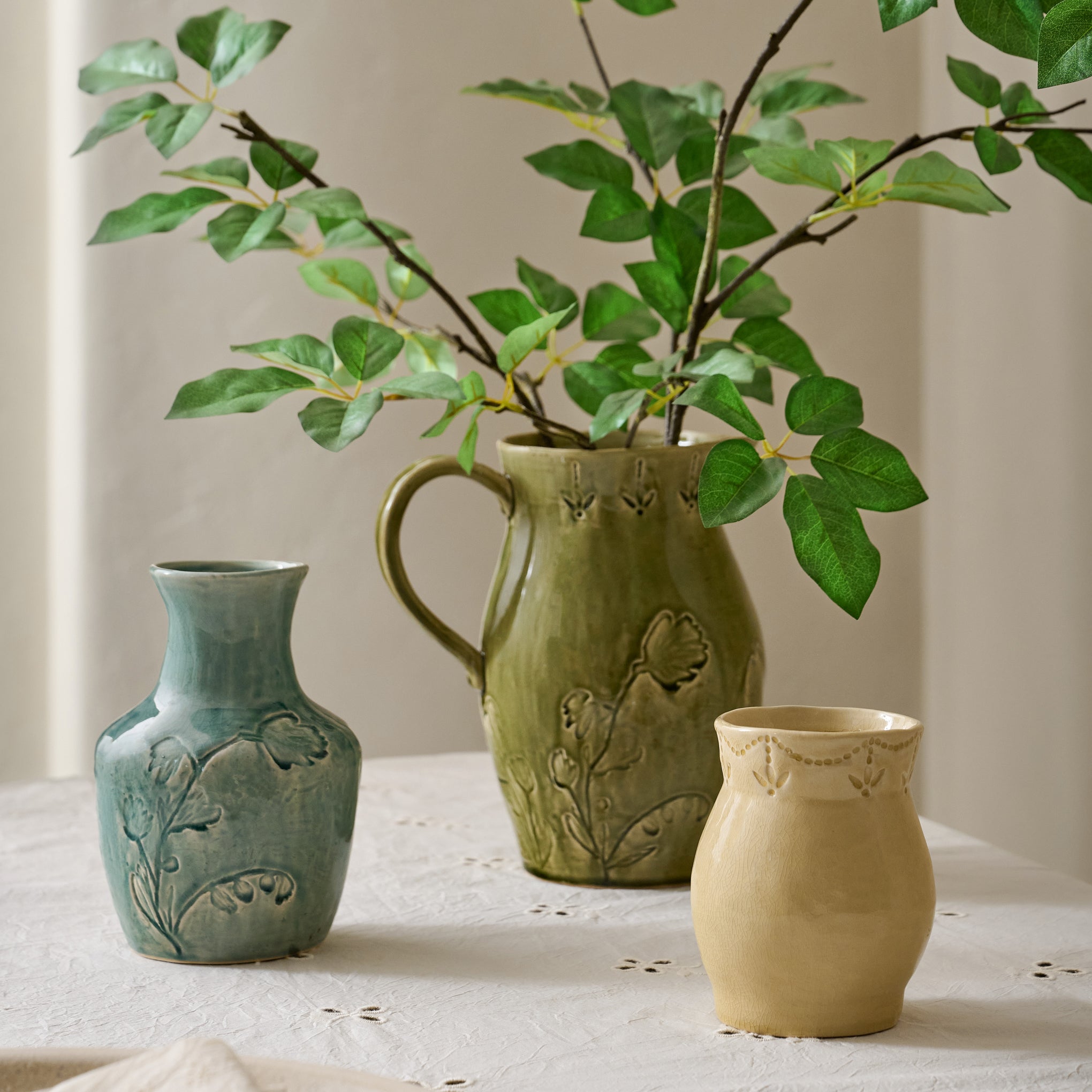 Floral Glazed Ceramic Gracie Vase shown with other glazed ceramic vessels on table