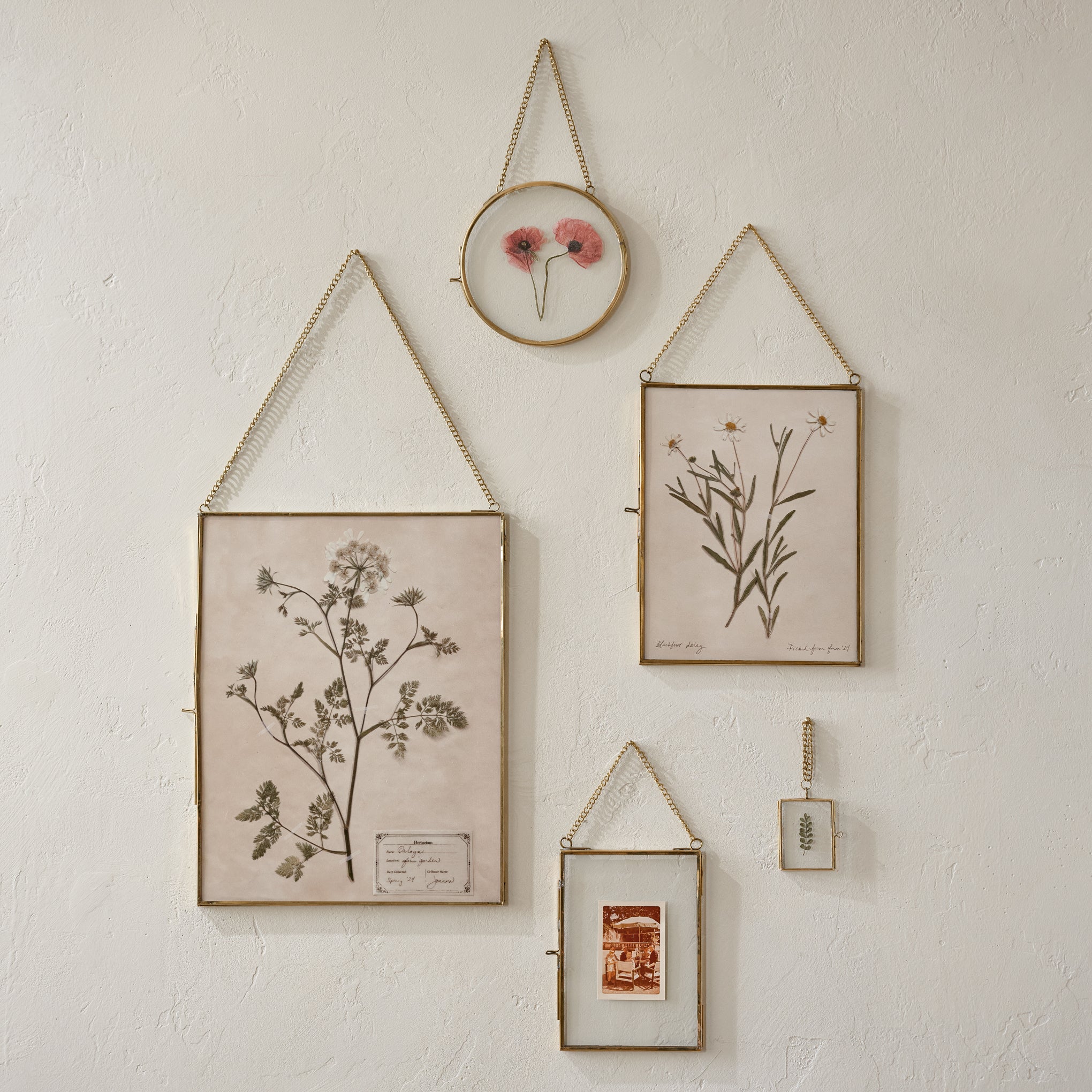 Josie Hanging Brass Photo Frames shown on wall