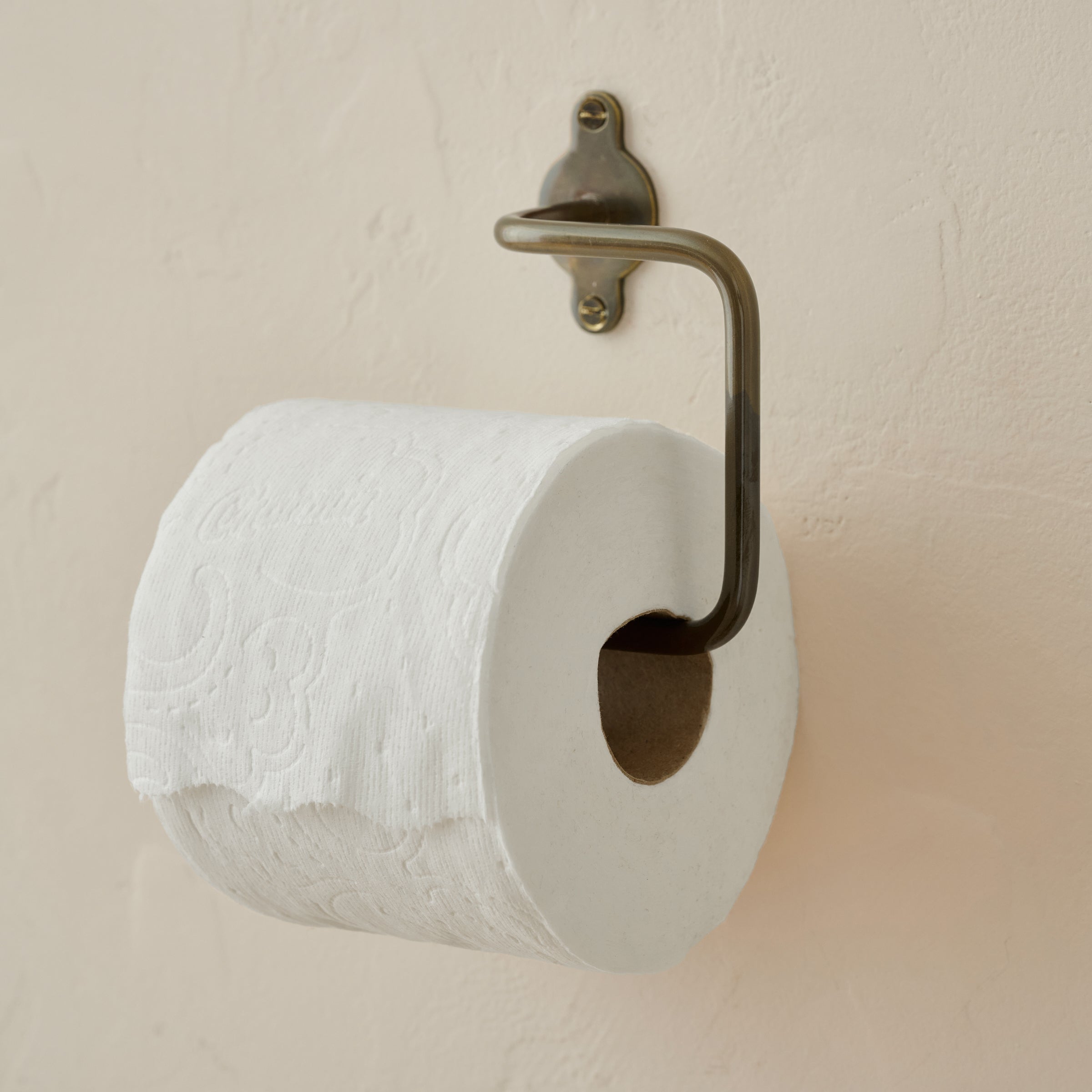 Antique Bronze Metal Toilet Paper Holder shown with toilet paper