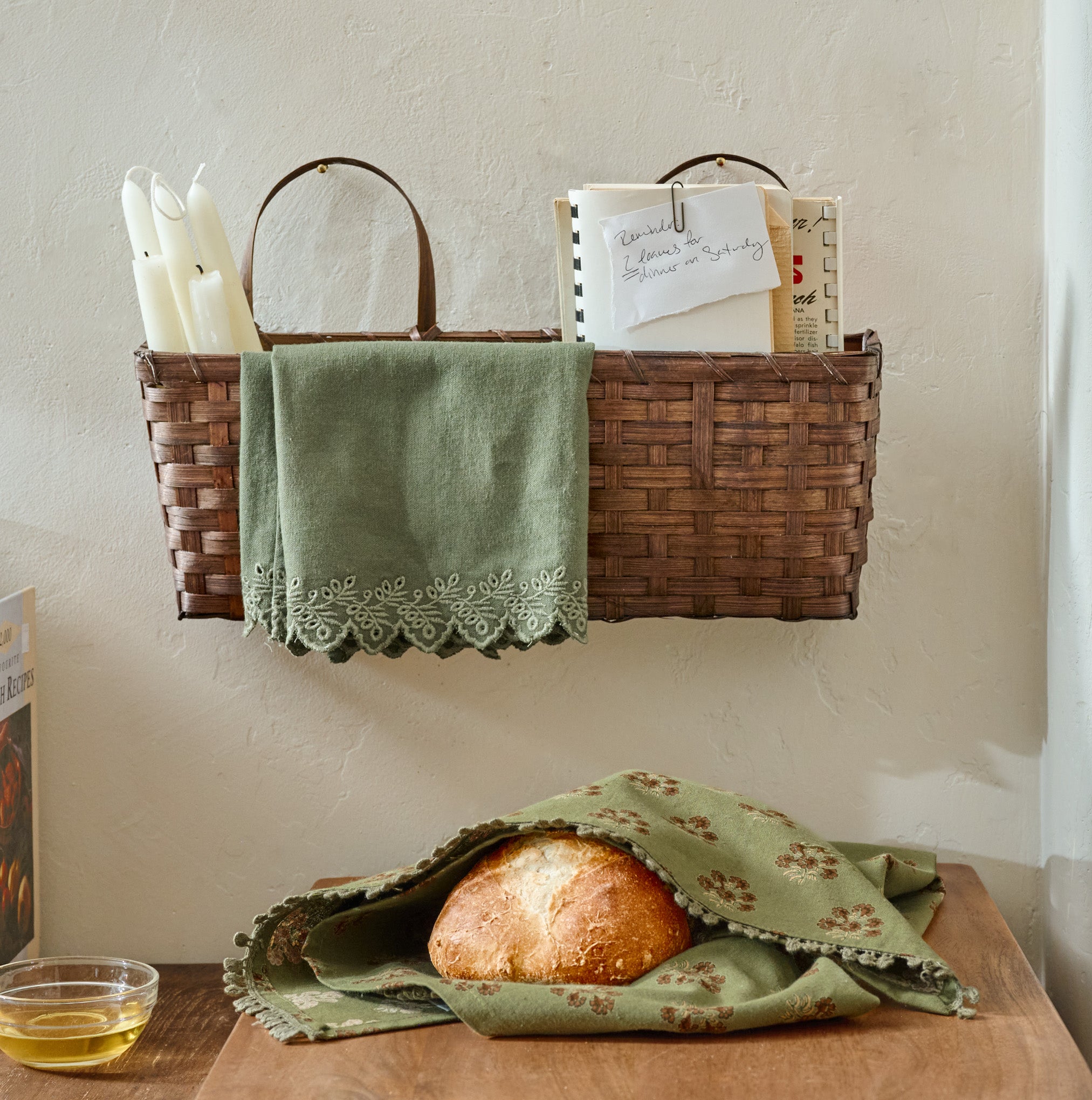 Magnoliass Embroidered Scalloped Edge Tea Towel shown in basket on wall