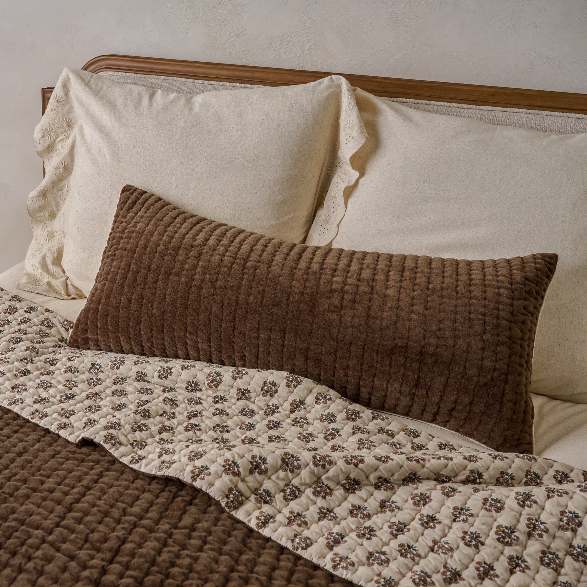 Audrey Velvet Lumbar Pillow- Cedar shown on bed
