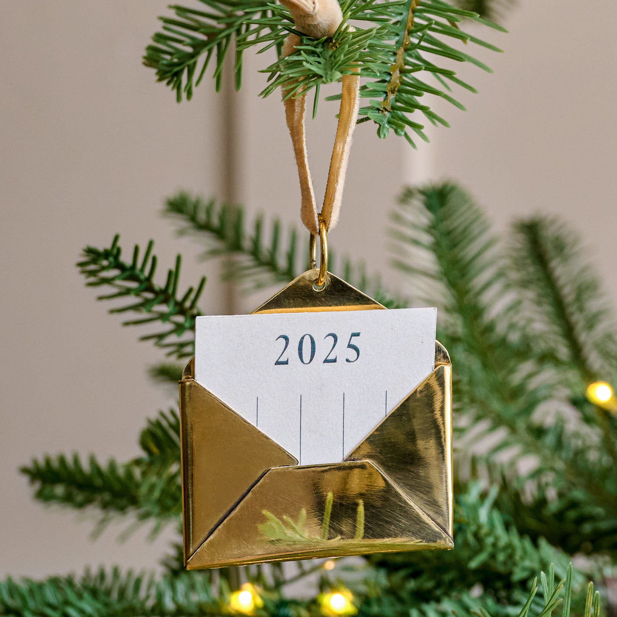 2025 Magnoliass Brass Keepsake Envelope Ornament on a tree