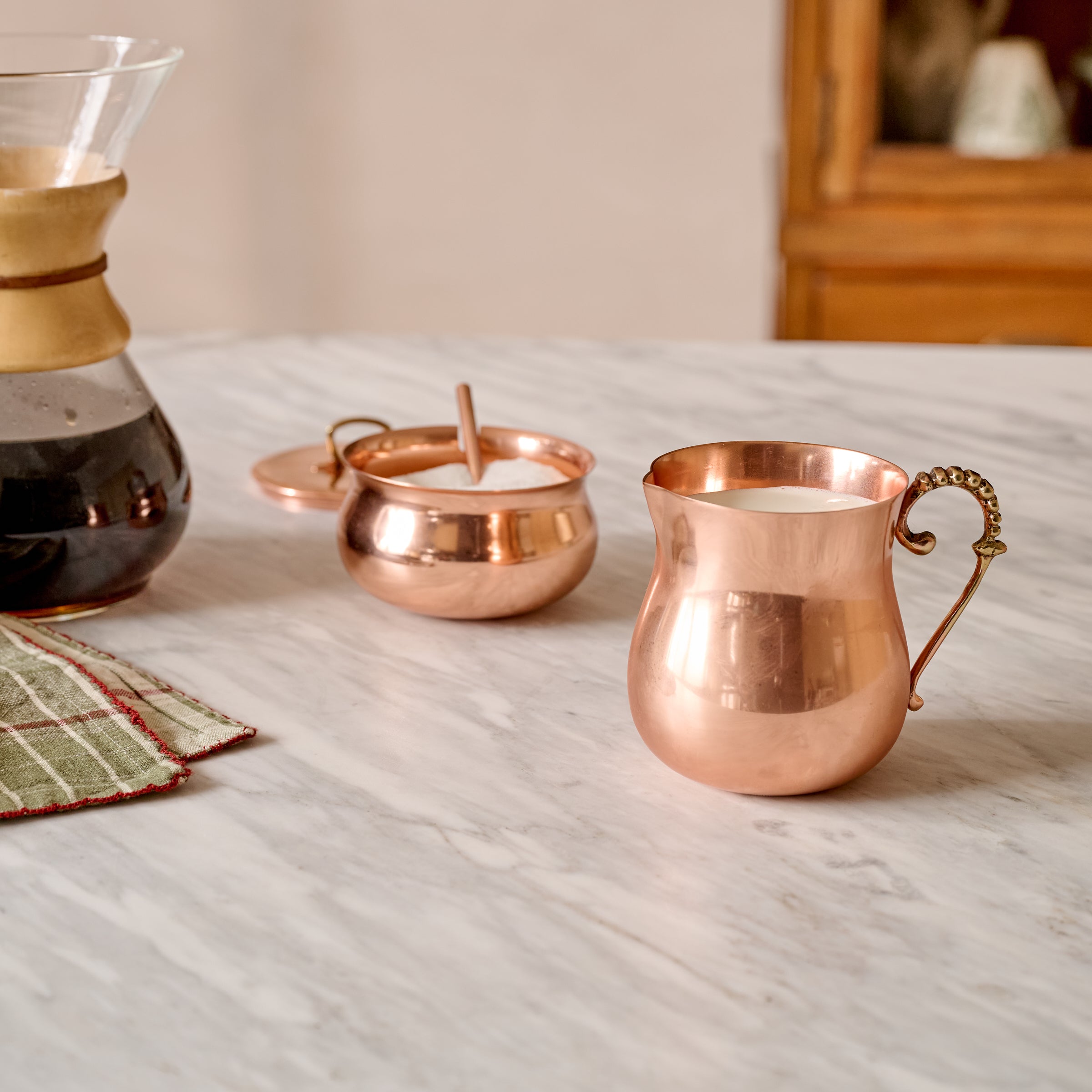 Antique Copper Sugar Canister shown on counter with matching creamer