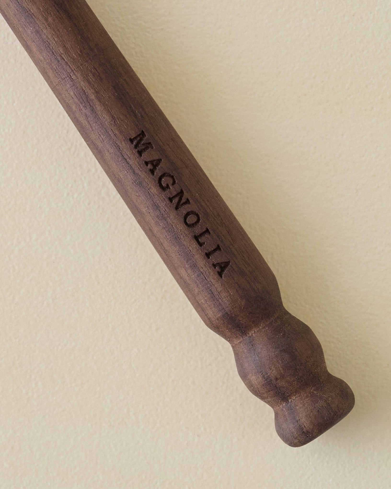 Walnut Spoon with 'Magnolia' branding on a beige background