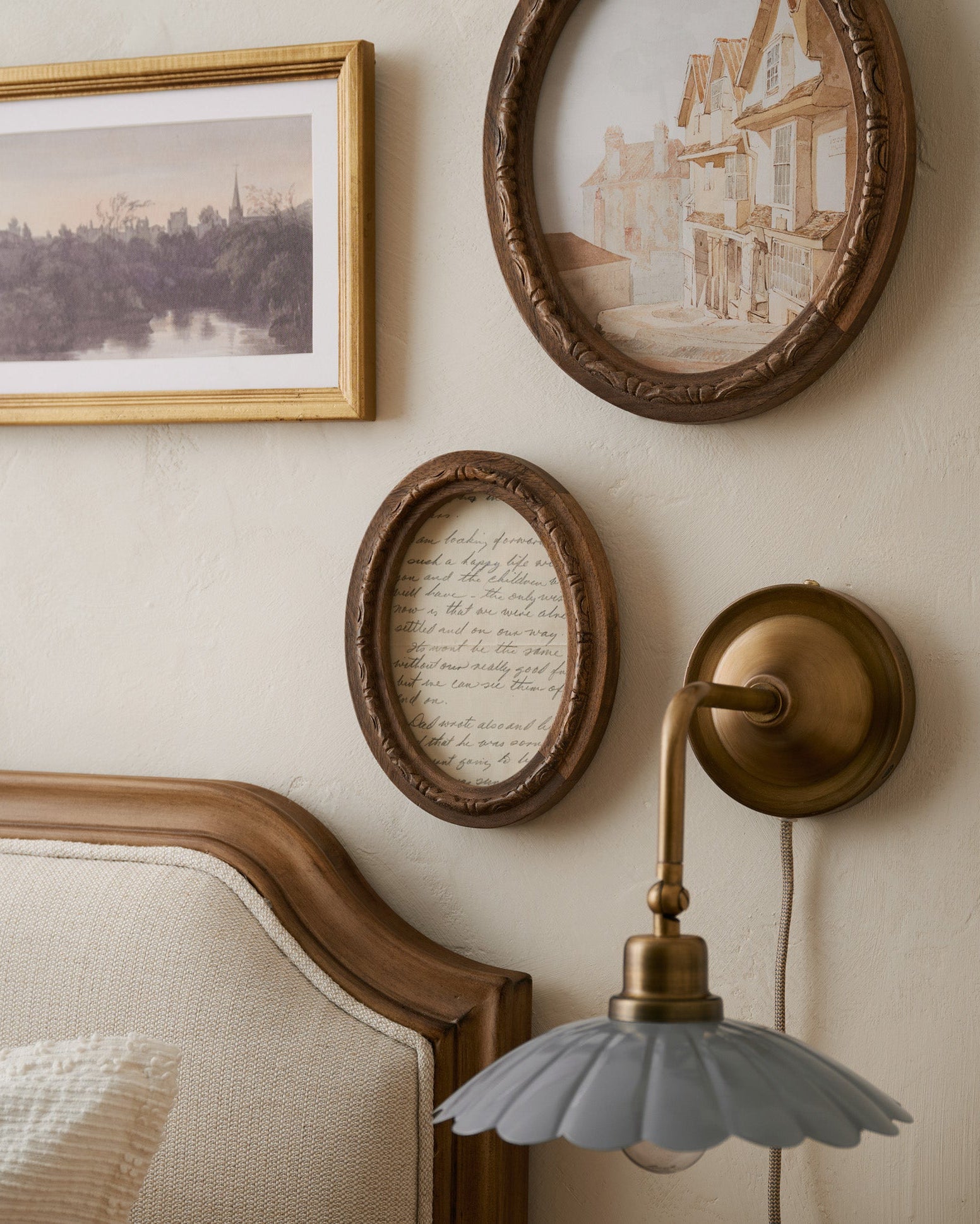 Caroline Carved Wood Oval Photo Frame in a bedroom above bedframe next to scalloped wall sconce