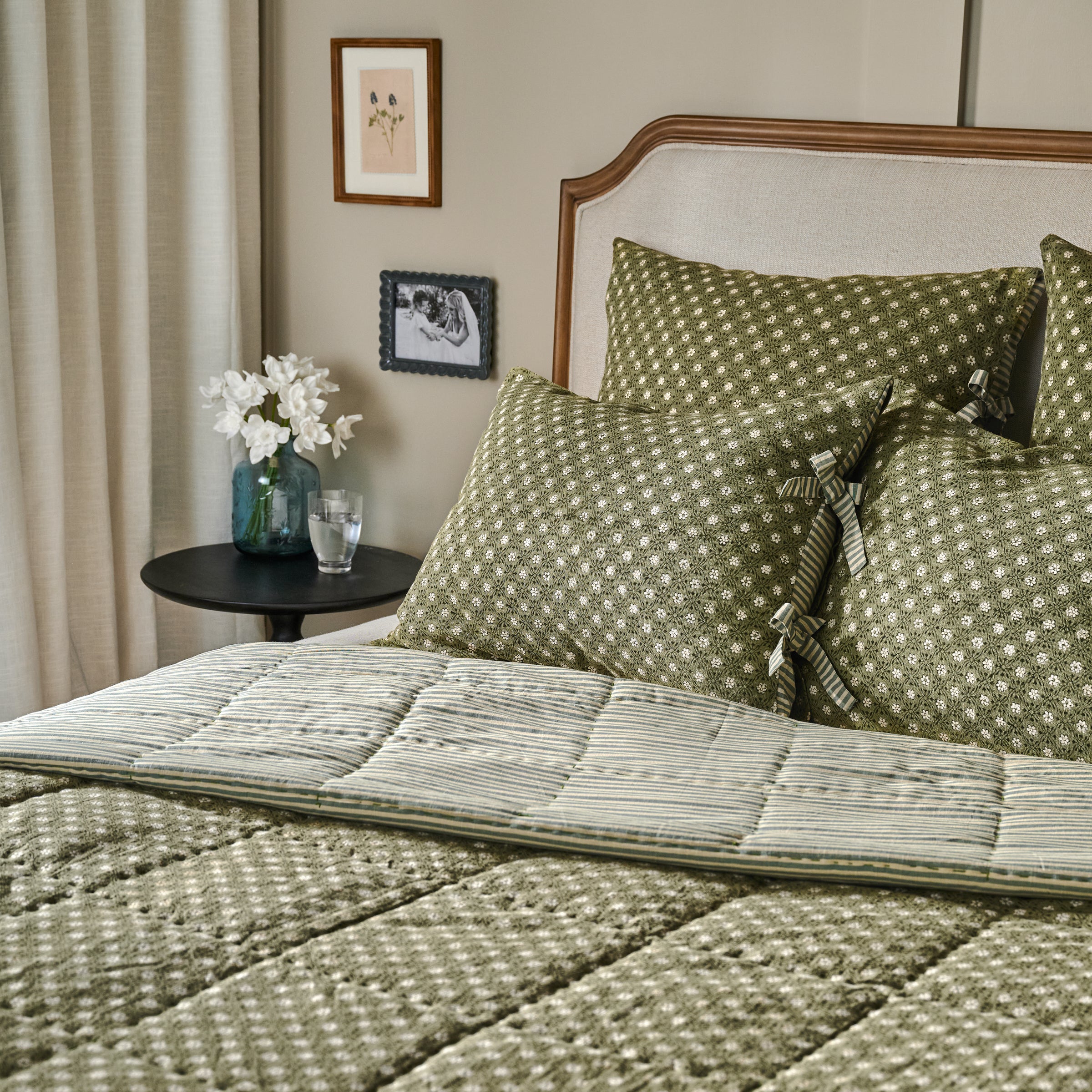 Thea Reversible Quilt on bed next to black end table