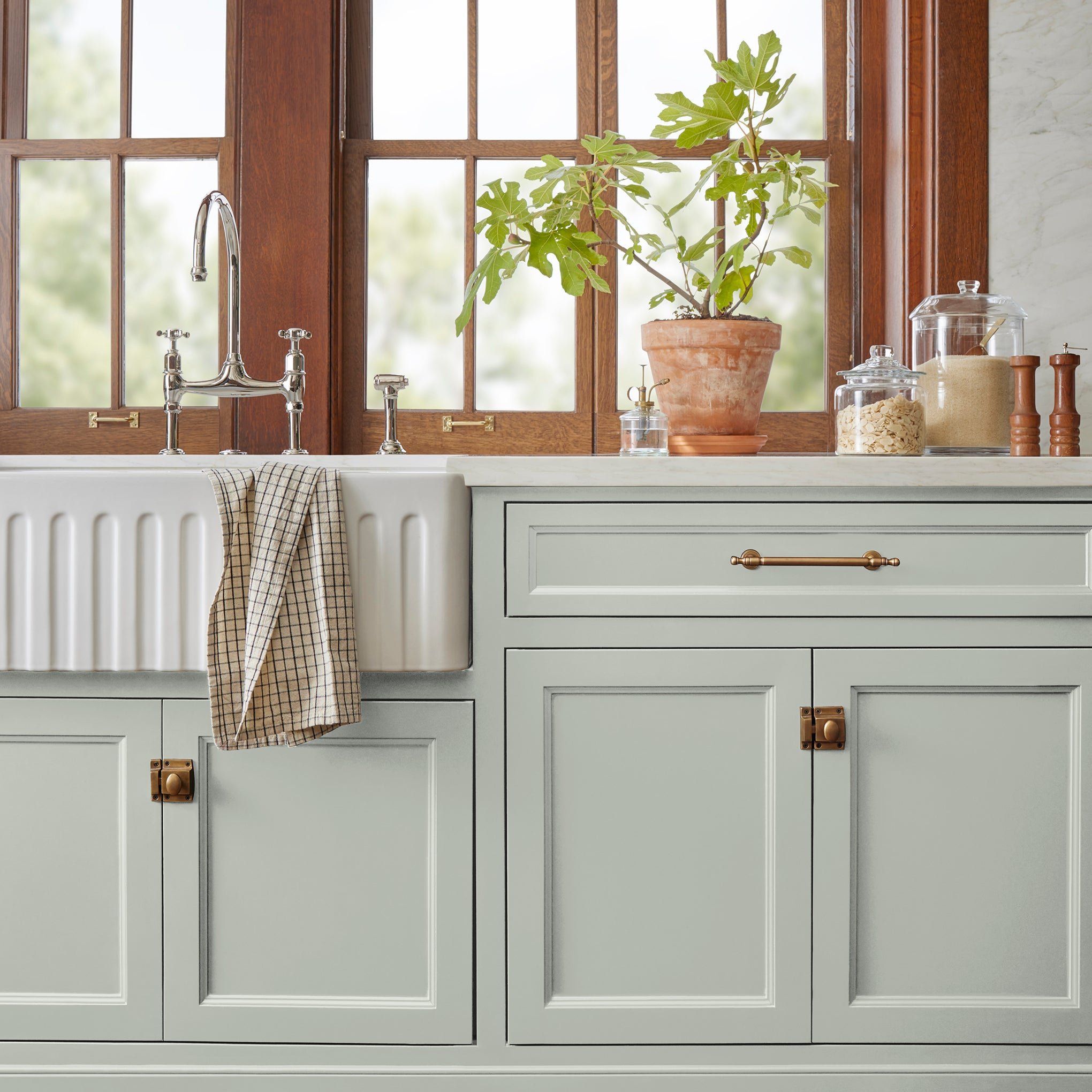 Light blue grey with light green undertone paint named Emmie's Room shown painted on kitchen cabinet.