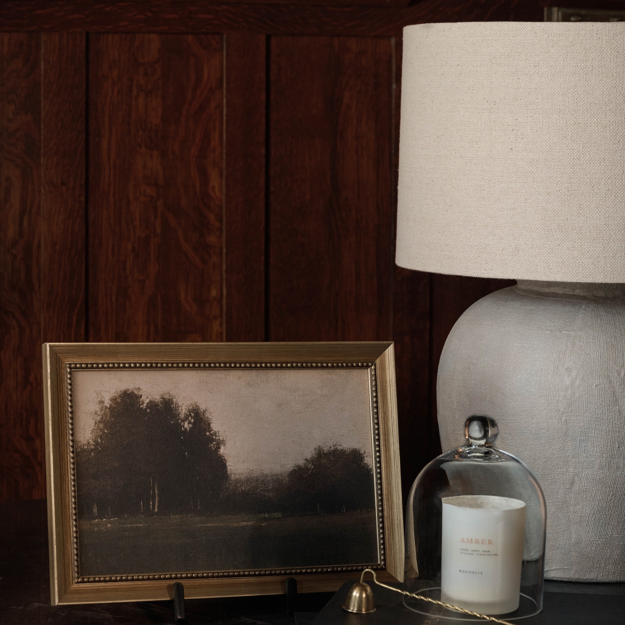 Petite Quiet Field next to a candle and a lamp