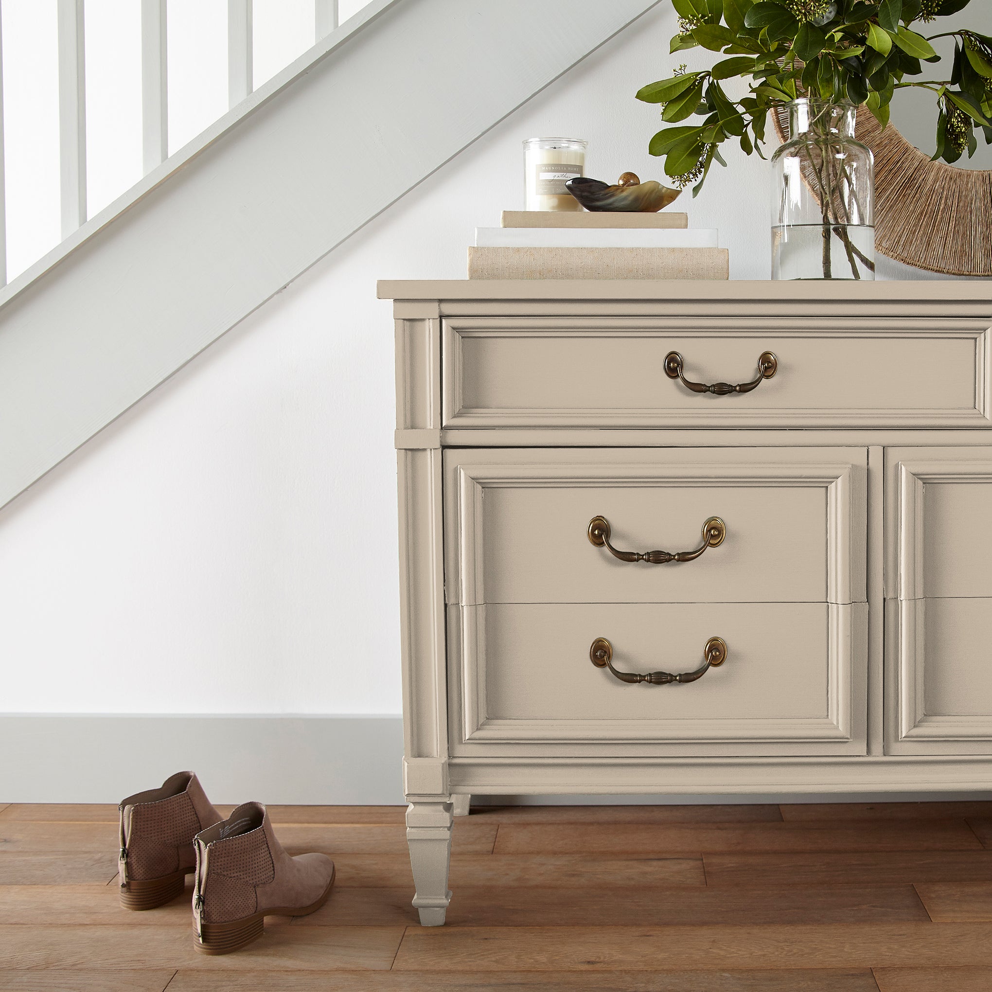 light tan with a yellow undertone door and cabinet paint named soft landing show painted on entryway cabinet.