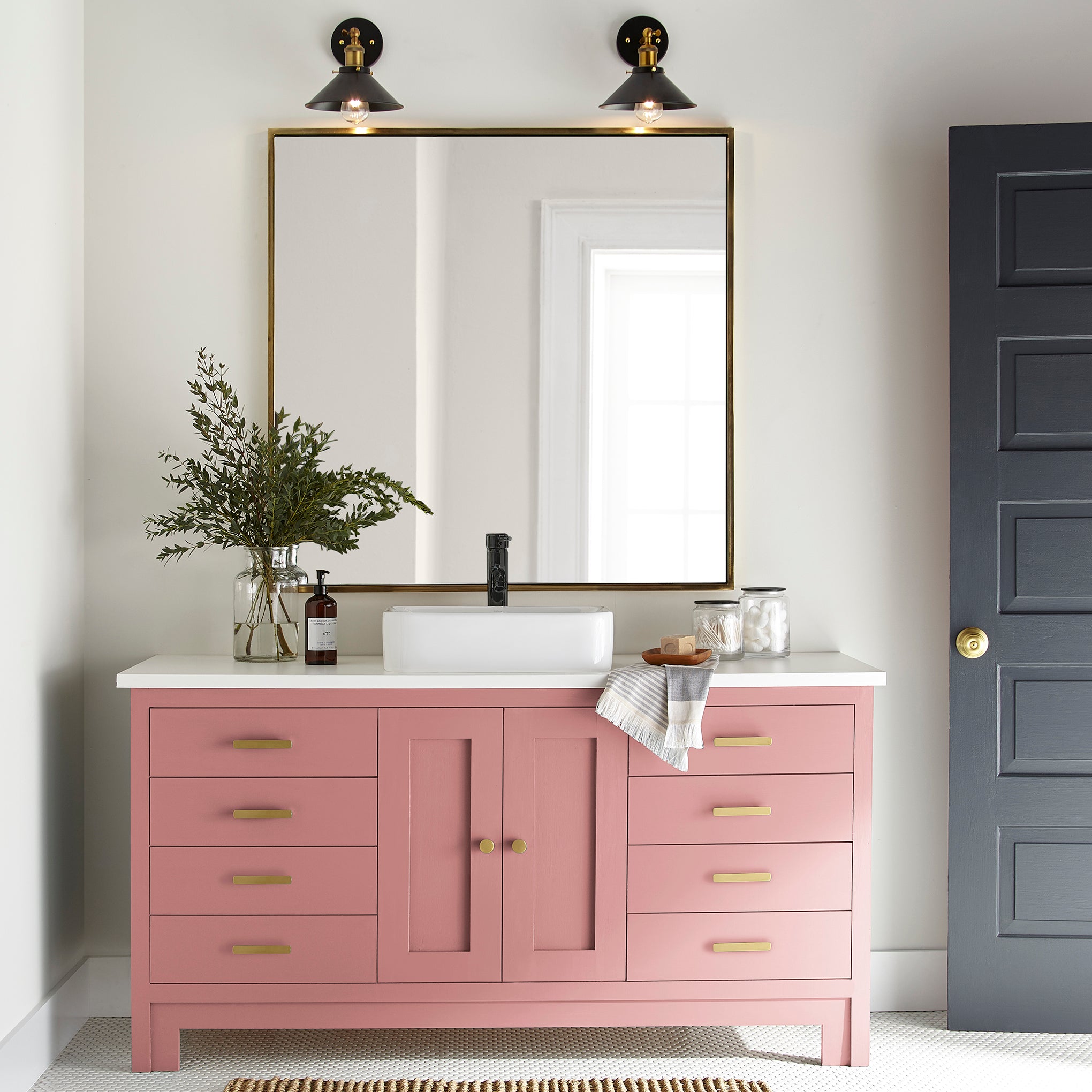 a coral pink trim, door and cabinetry paint named pink lemonade shown painted on bathroom cabinet
