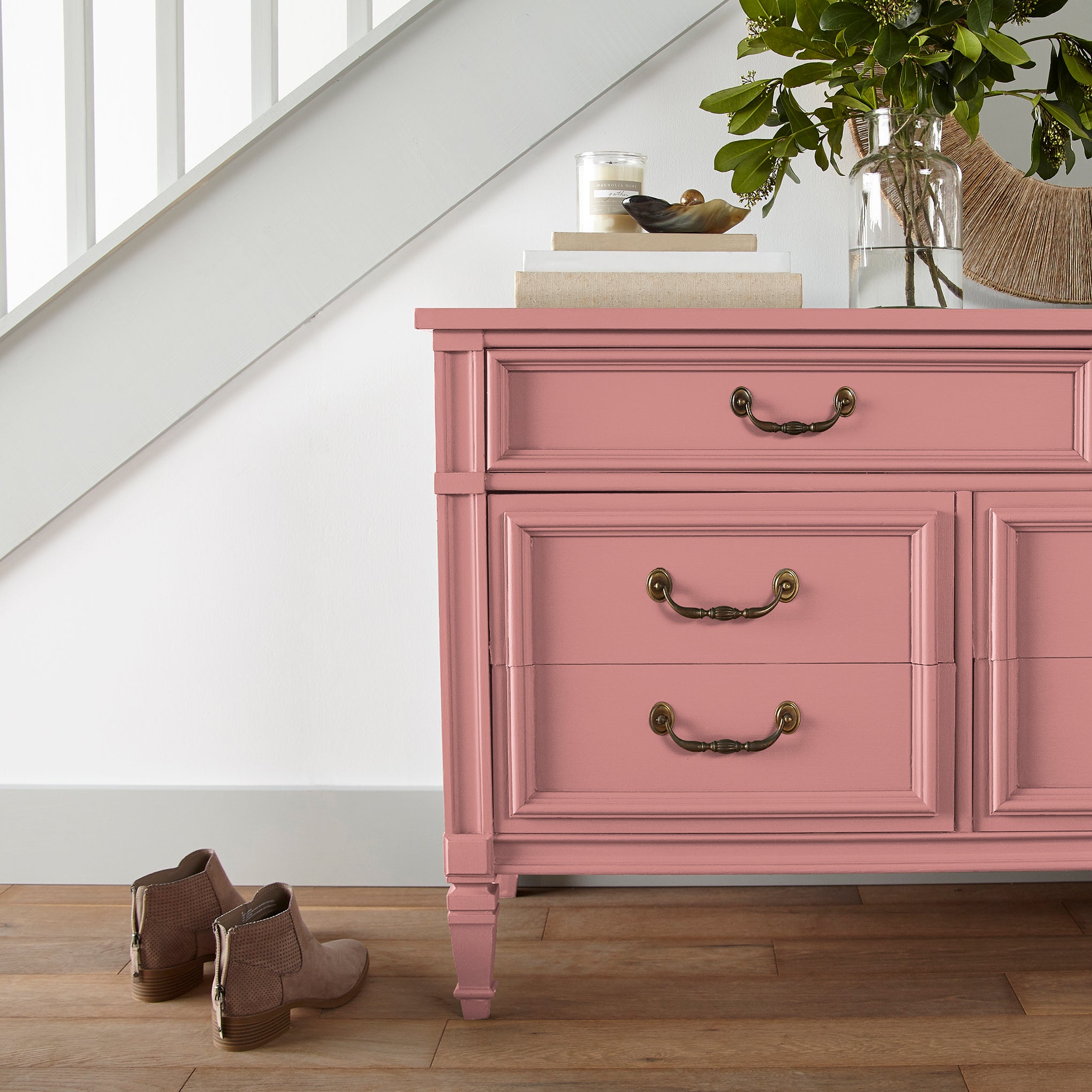 a coral pink trim, door and cabinetry paint named pink lemonade shown painted on entryway cabinet