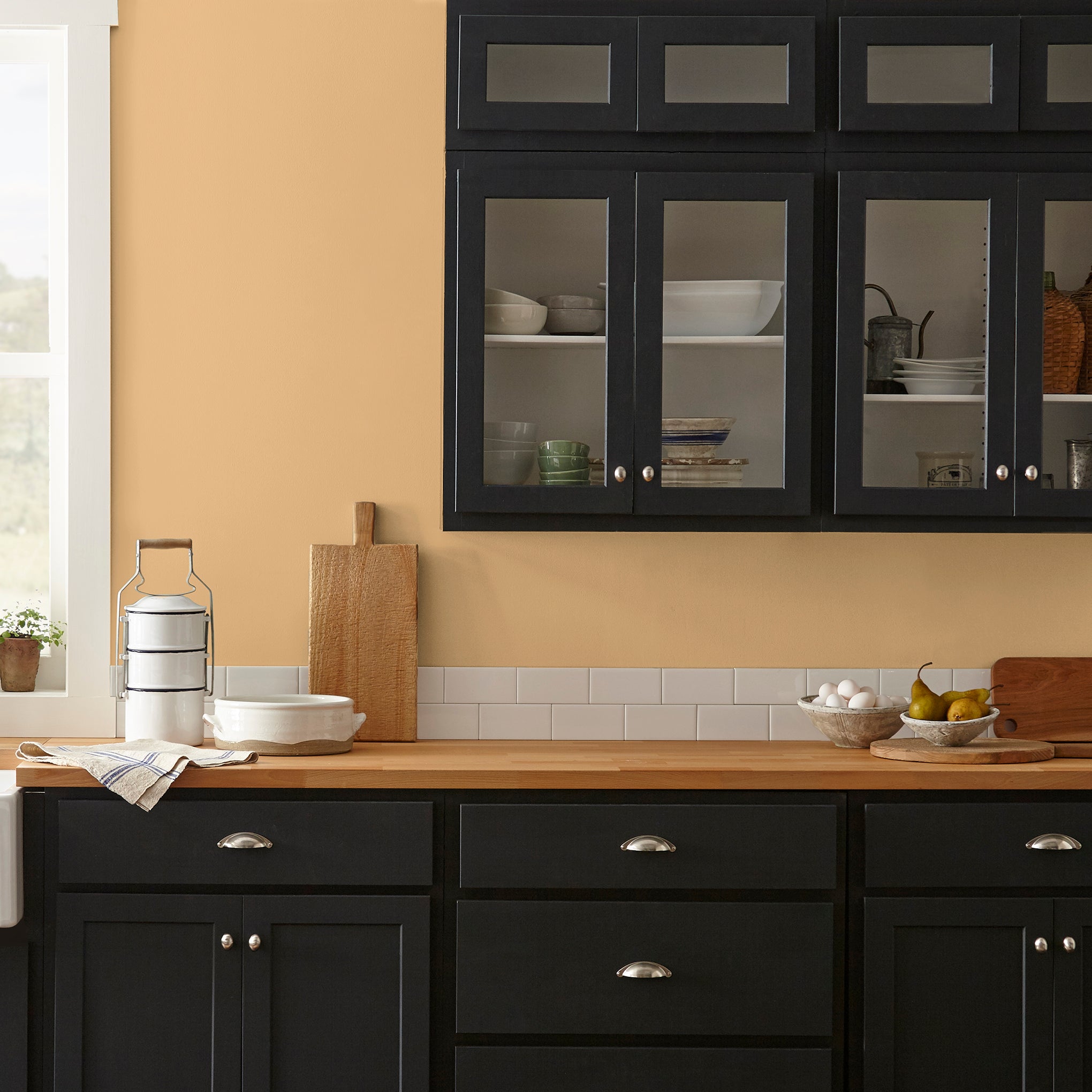Muted mid-toned yellow interior paint named cottage feel shown painted on kitchen wall