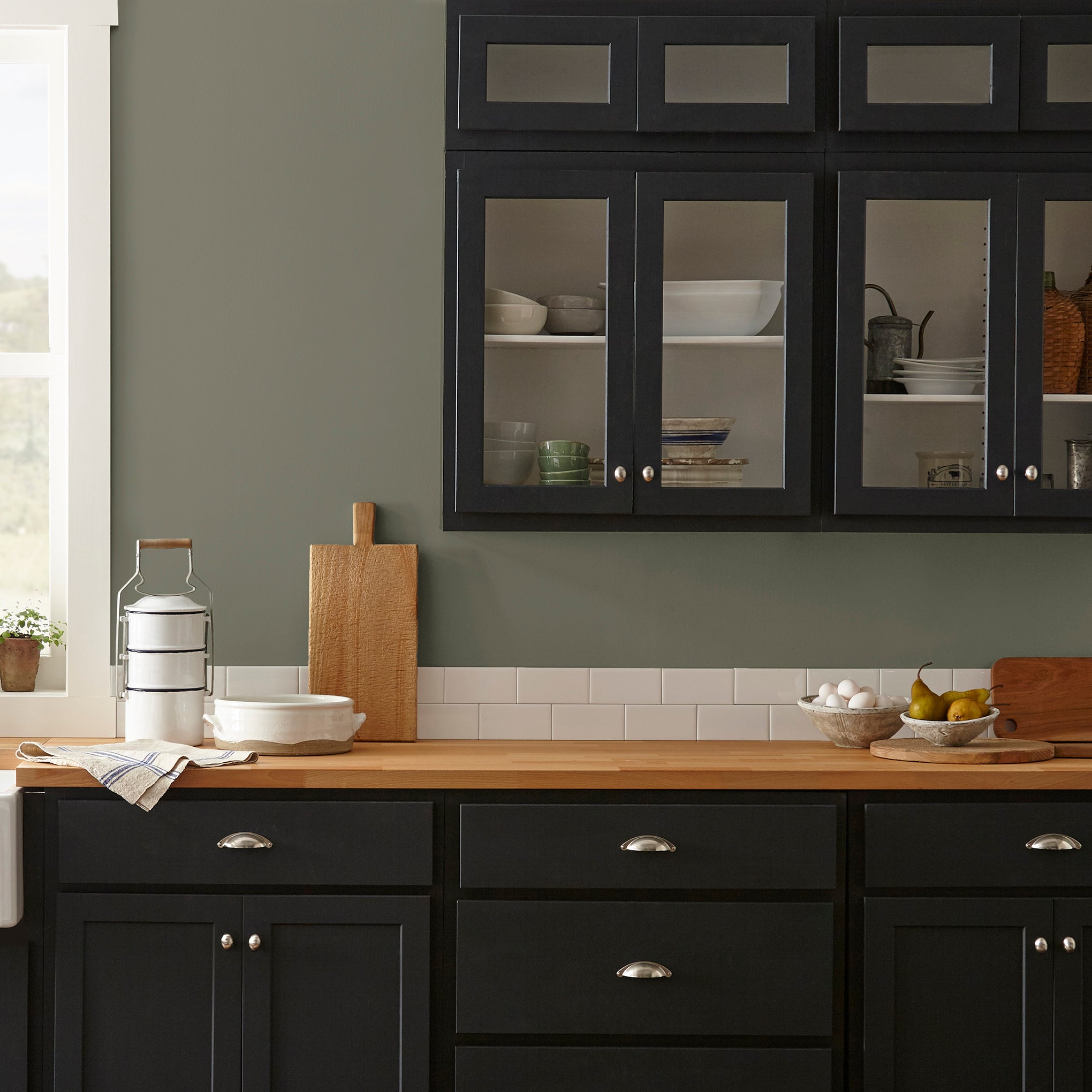 A warm olive green interior paint named market place shown painted on kitchen wall