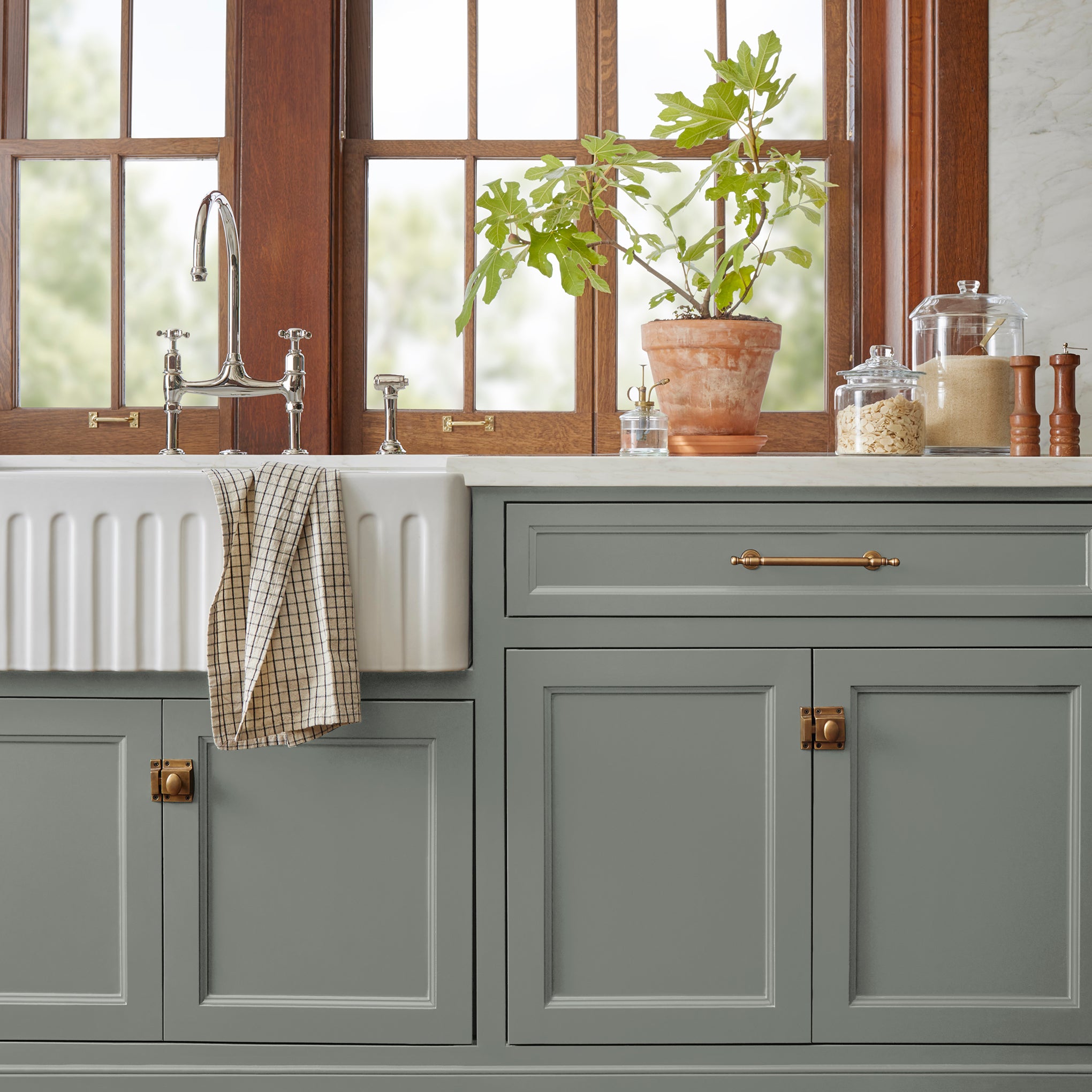 Mid-tone sage green blended with earthy gray door and cabinet paint named sage stem shown painted on kitchen cabinet  