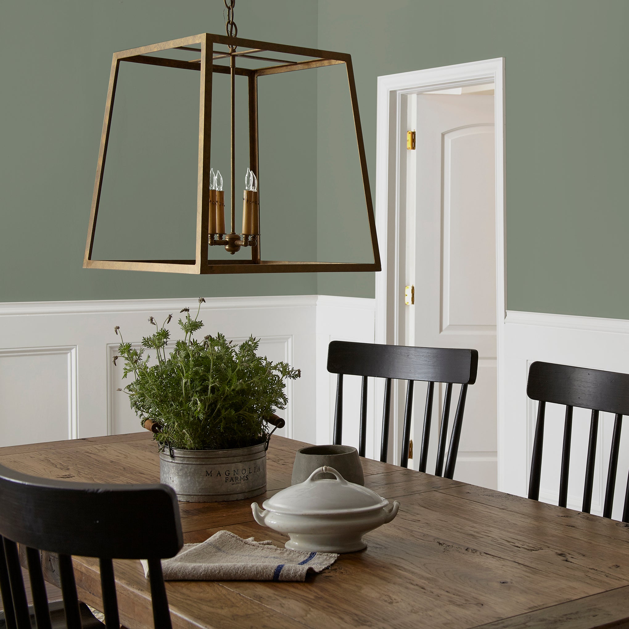 A dusty olive green interior paint named bespoke green shown painted on dining room wall