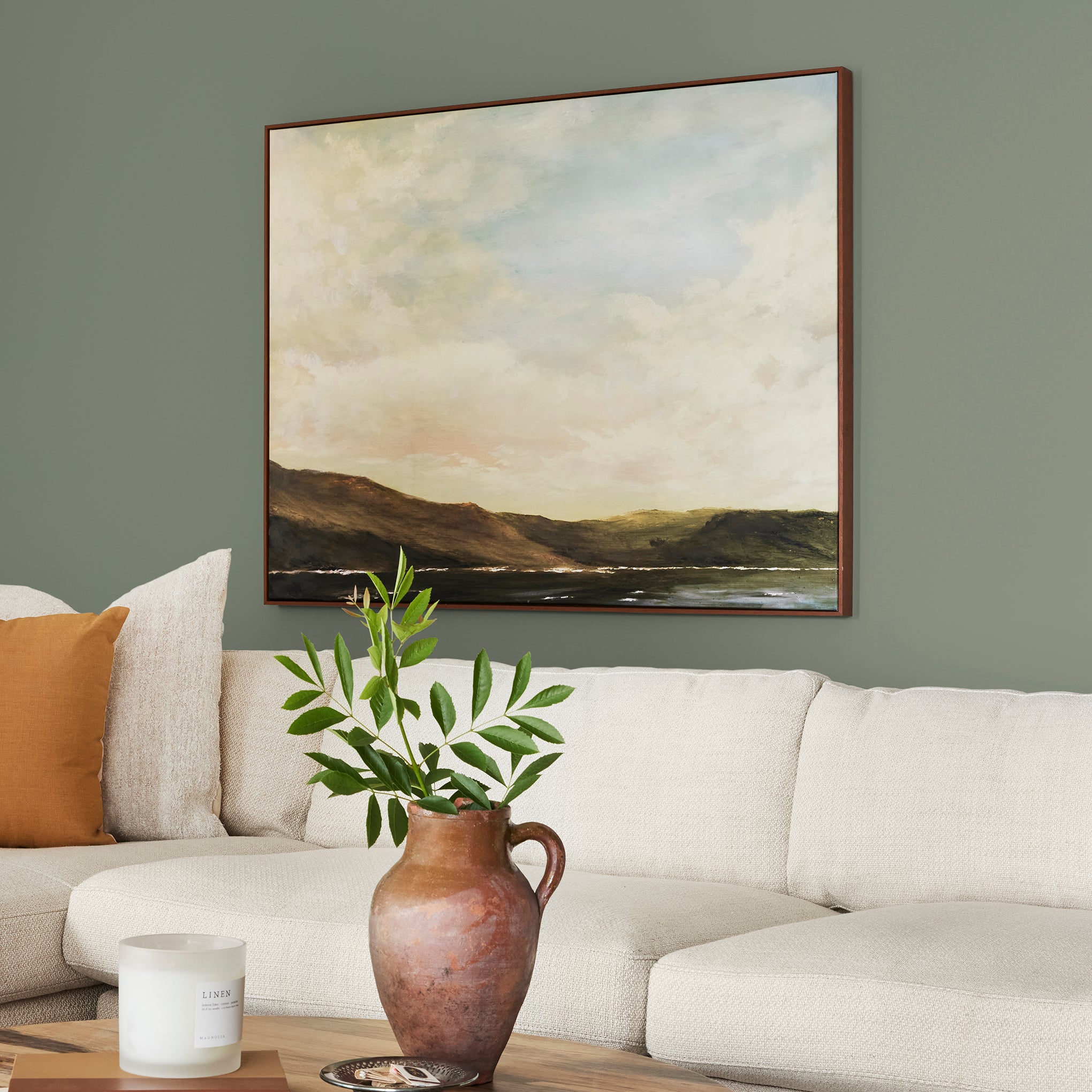 A dusty olive green interior paint named bespoke green shown painted on living room wall
