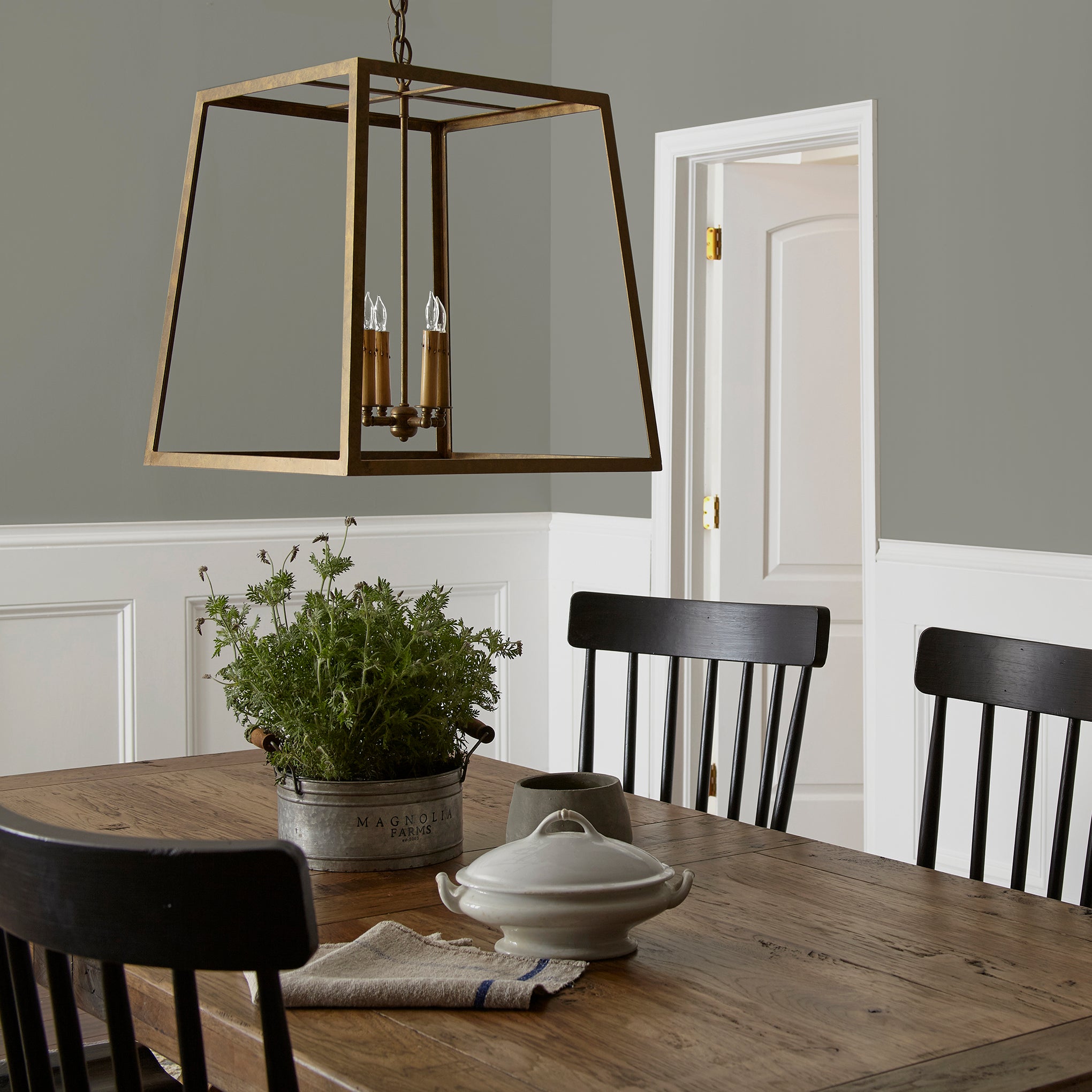 dark gray with olive green undertone paint named boutique gray shown painted on dining room wall