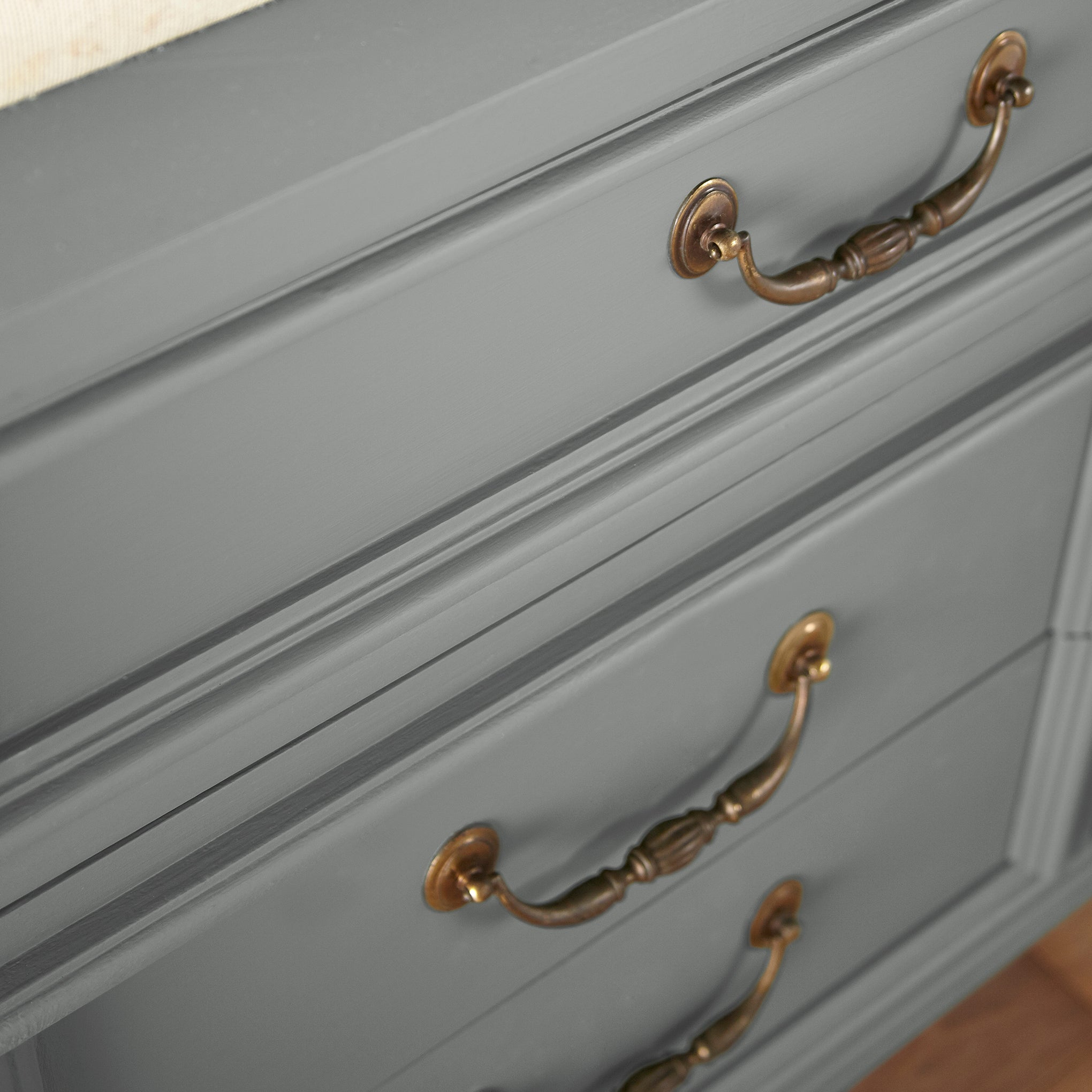 A dark gray with blue and green undertones door and cabinet paint named teak cups shown painted on cabinet