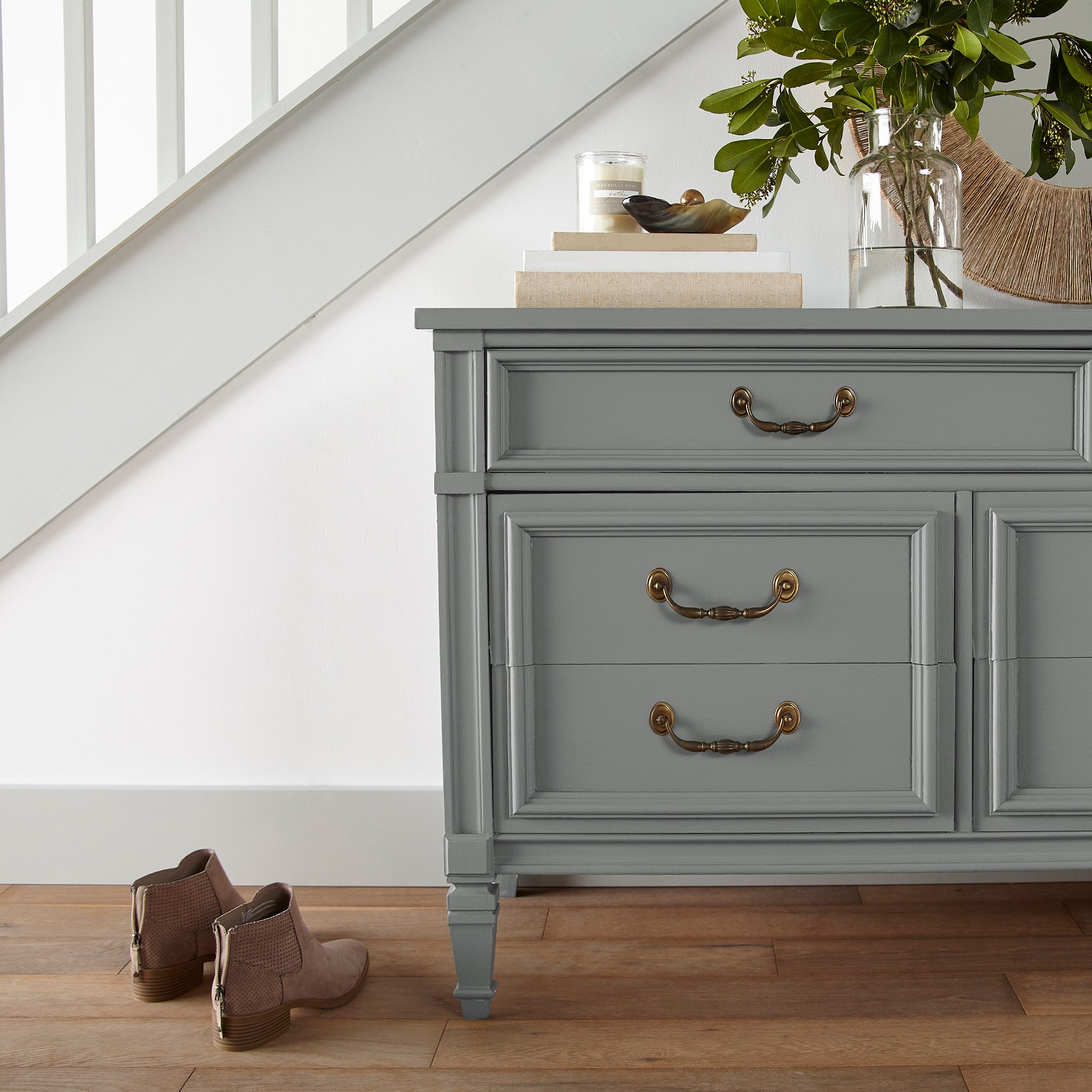 A dark gray with blue and green undertones door and cabinet paint named teak cups shown painted on entryway cabinet