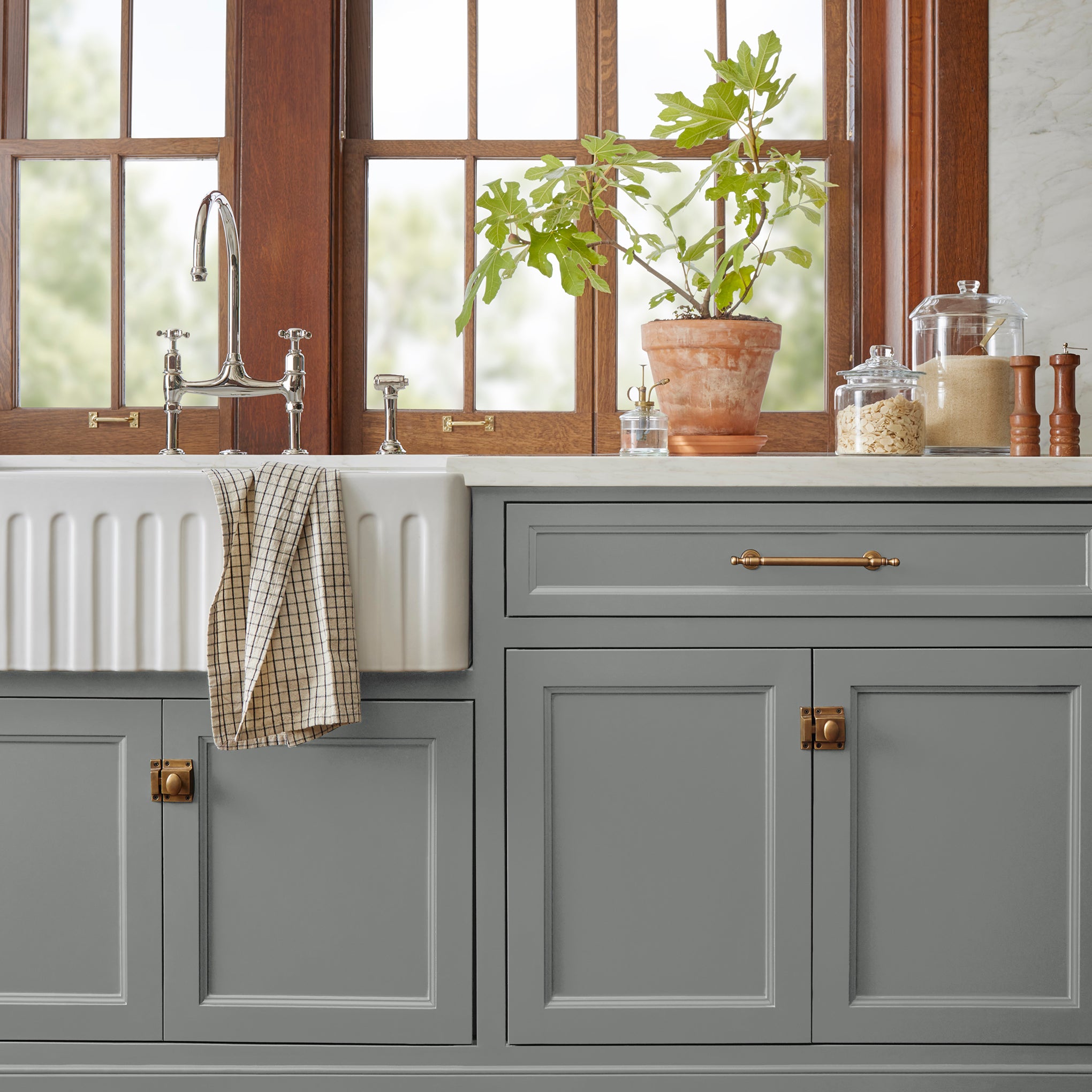 A dark gray with blue and green undertones door and cabinet paint named teak cups shown painted on kitchen cabinet