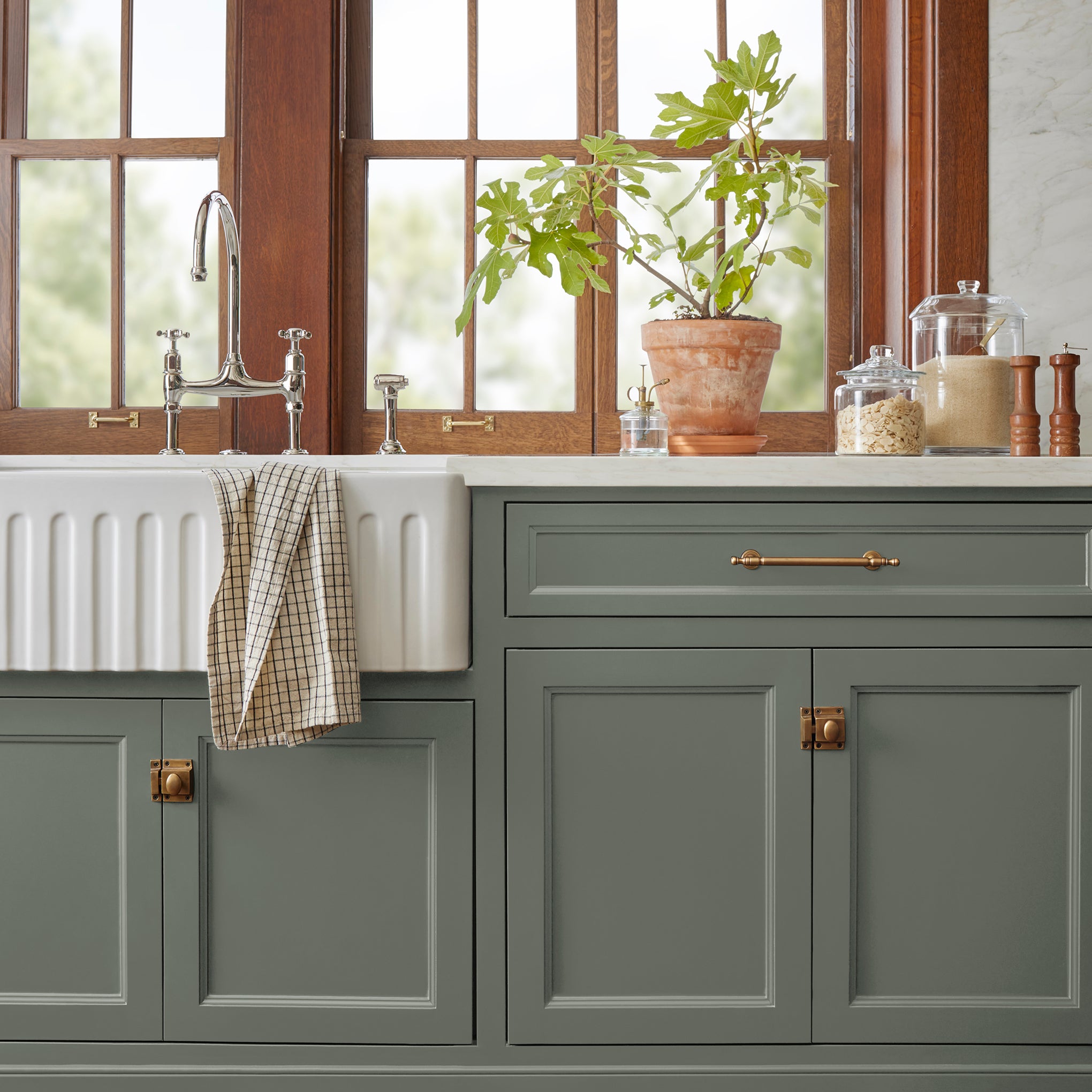 Almost army green with earthy brown and gray door and cabinet paint named wellington green shown painted on kitchen cabinet  