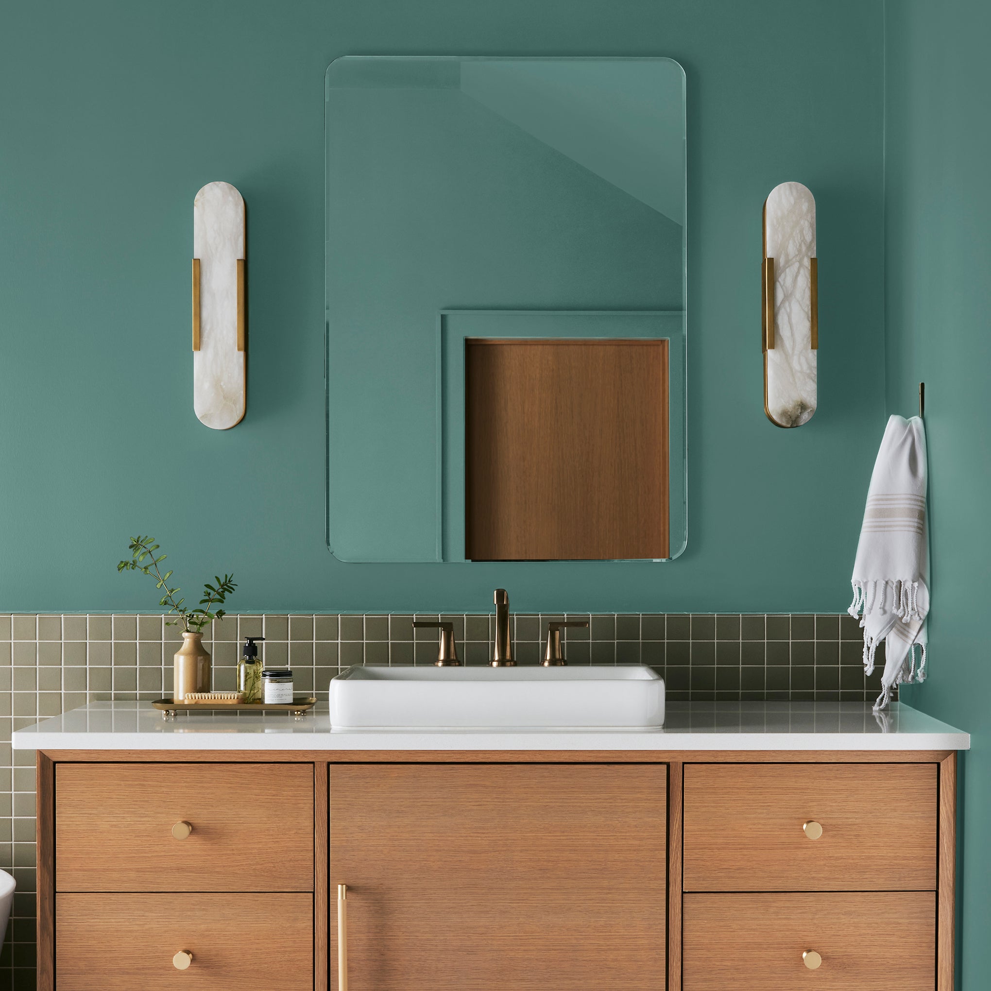 Dark aqua blue blended with a bit of ashy sage green interior paint named spontaneous shown painted on bathroom wall