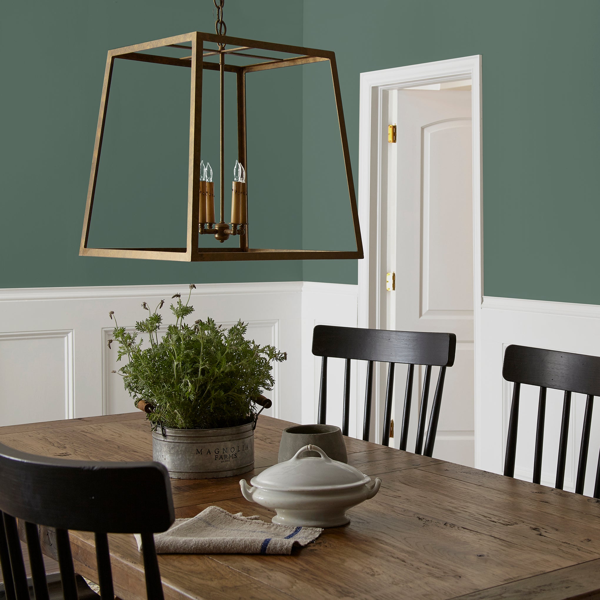 Deep hunter green interior paint named regal leaf shown painted on dining room wall