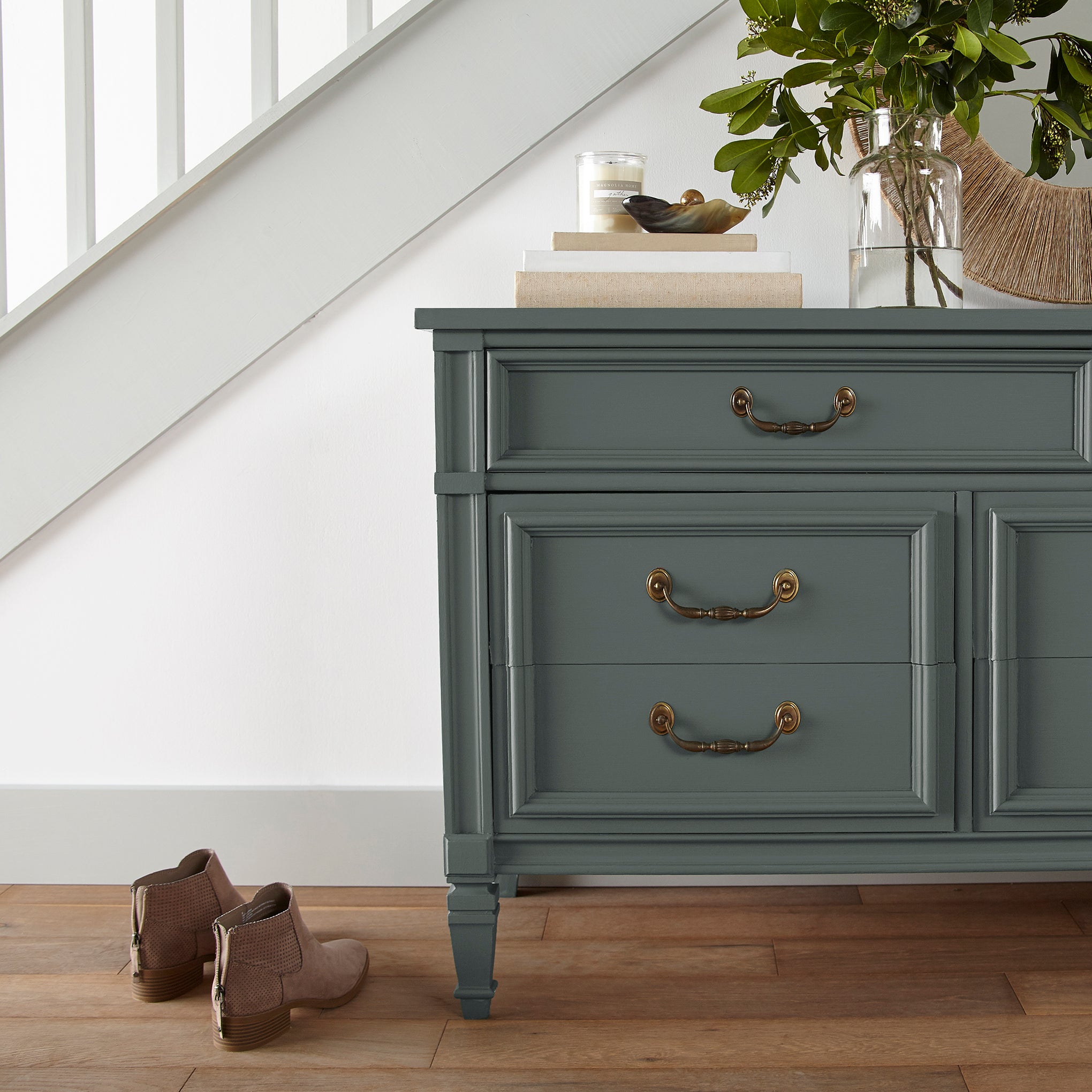 A slightly jeweled forest green hue door and cabinet paint named 1905 green shown painted on entryway cabinet