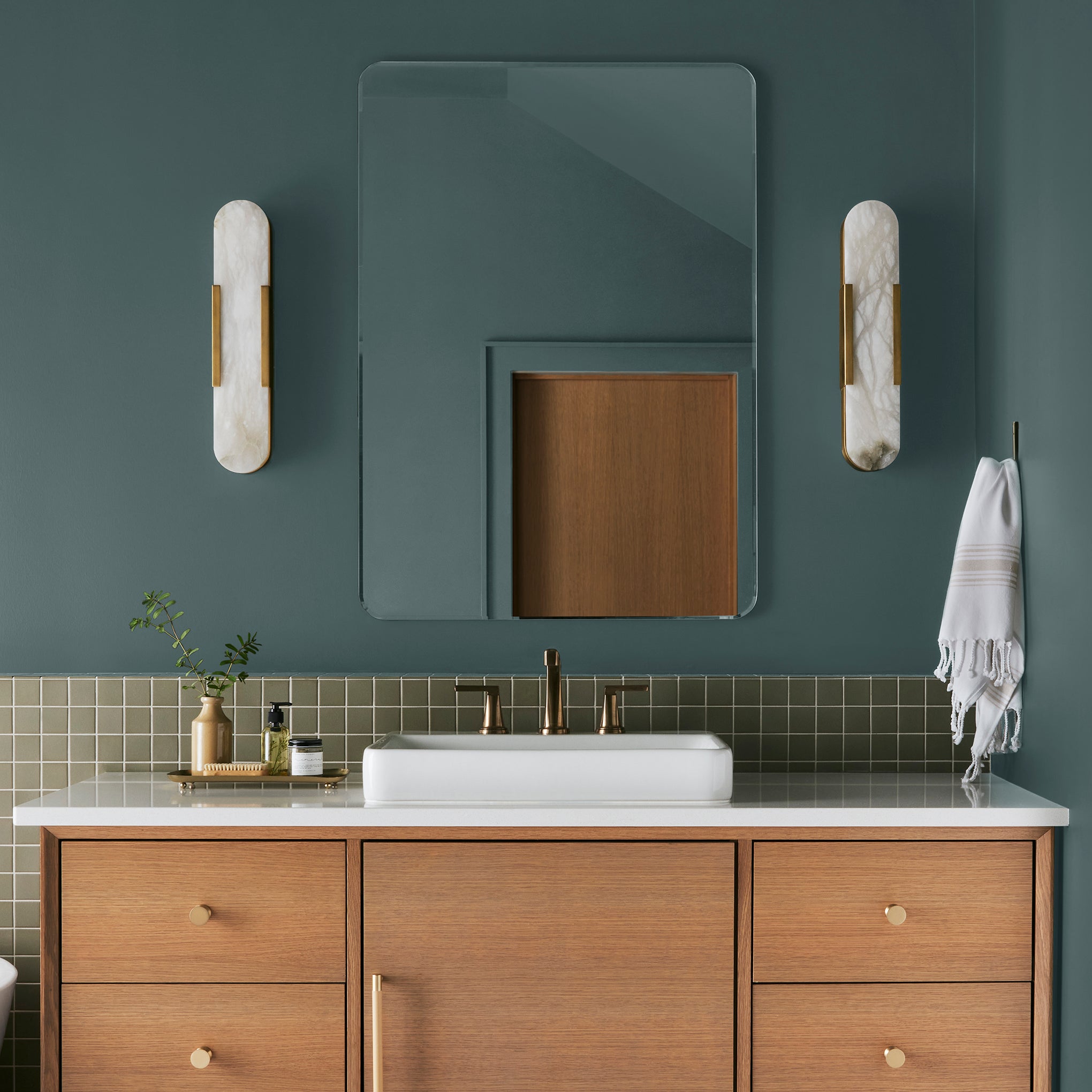 A deep peacock teal blue interior paint named secondhand find shown painted on bathroom wall