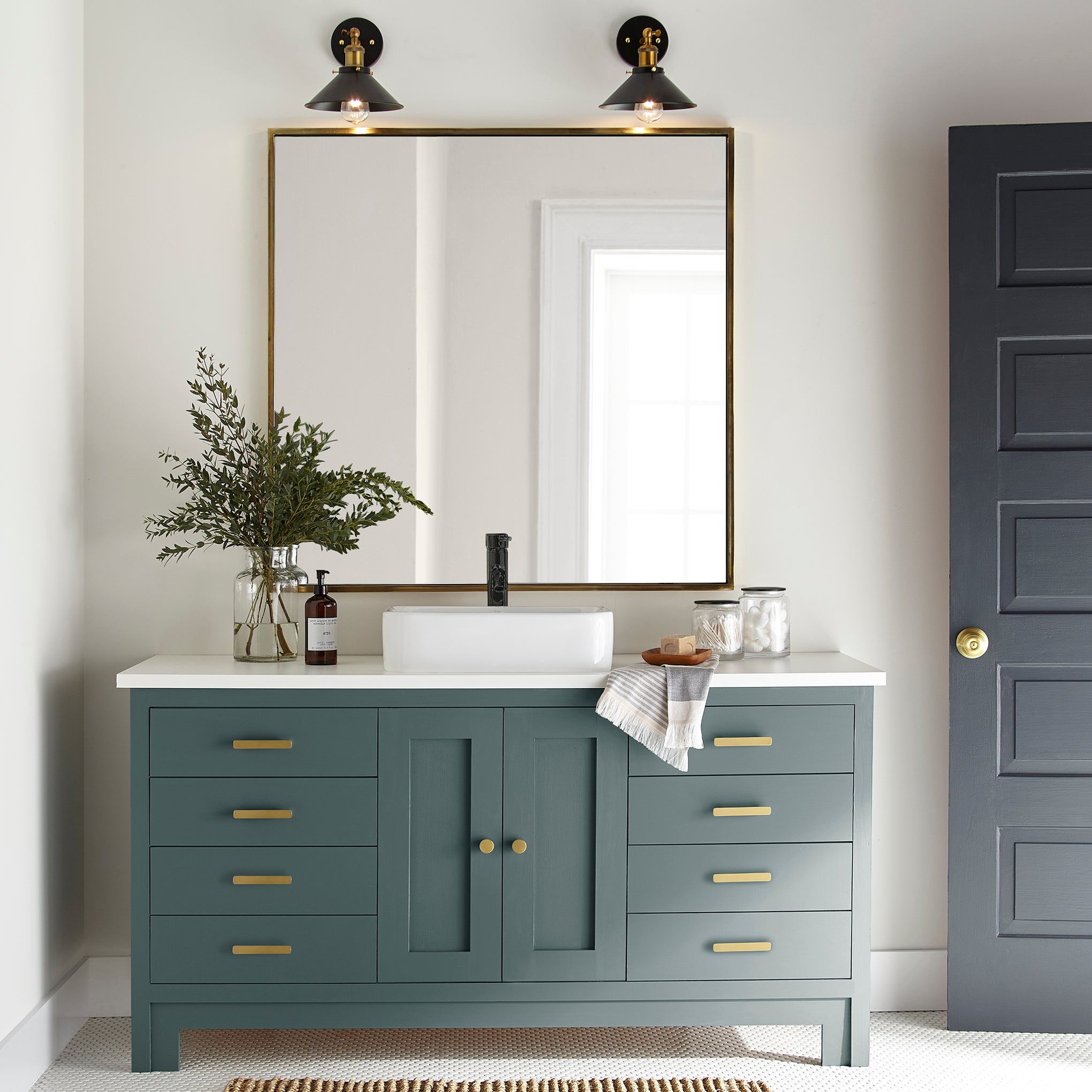 A muted peacock blue door and cabinet paint named secondhand find shown painted on bathroom cabinet