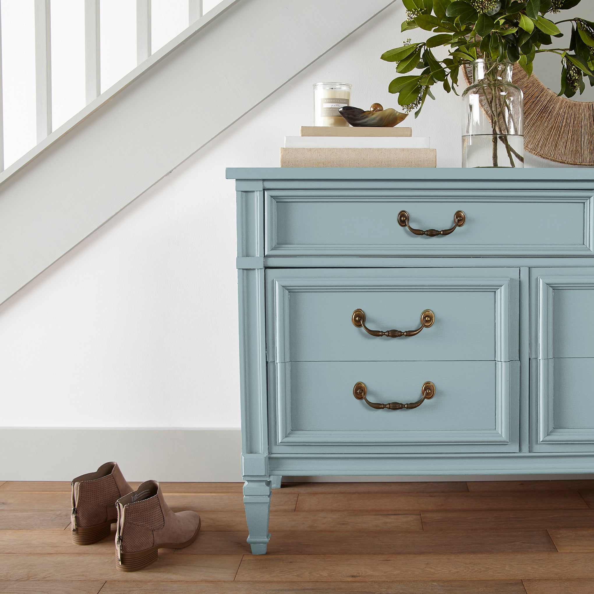 A muted blue door and cabinet paint named vibrant horizon shown painted on entryway cabinet