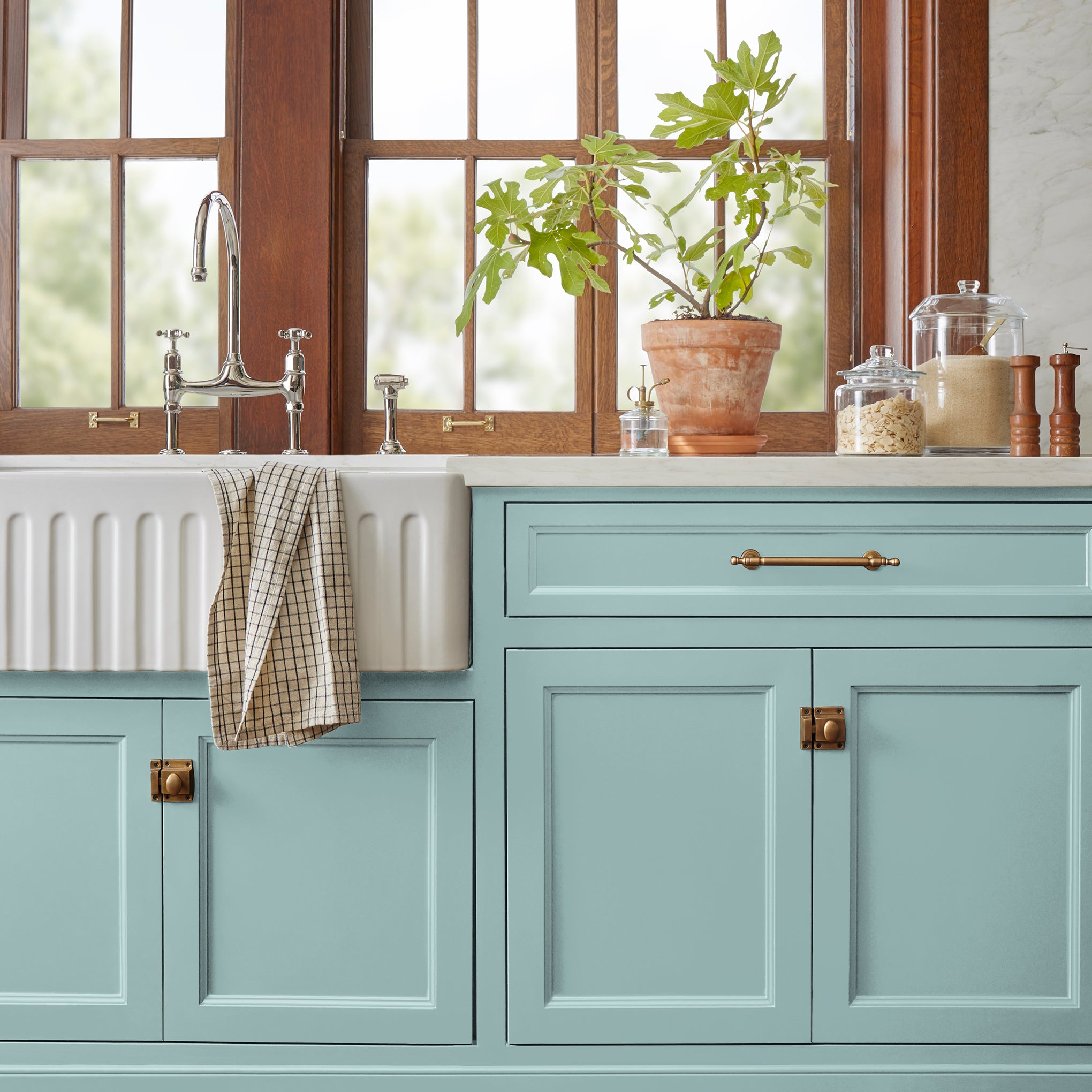 A sky blue muted with shades of gray door and cabinet paint named it is well shown painted on kitchen cabinet  