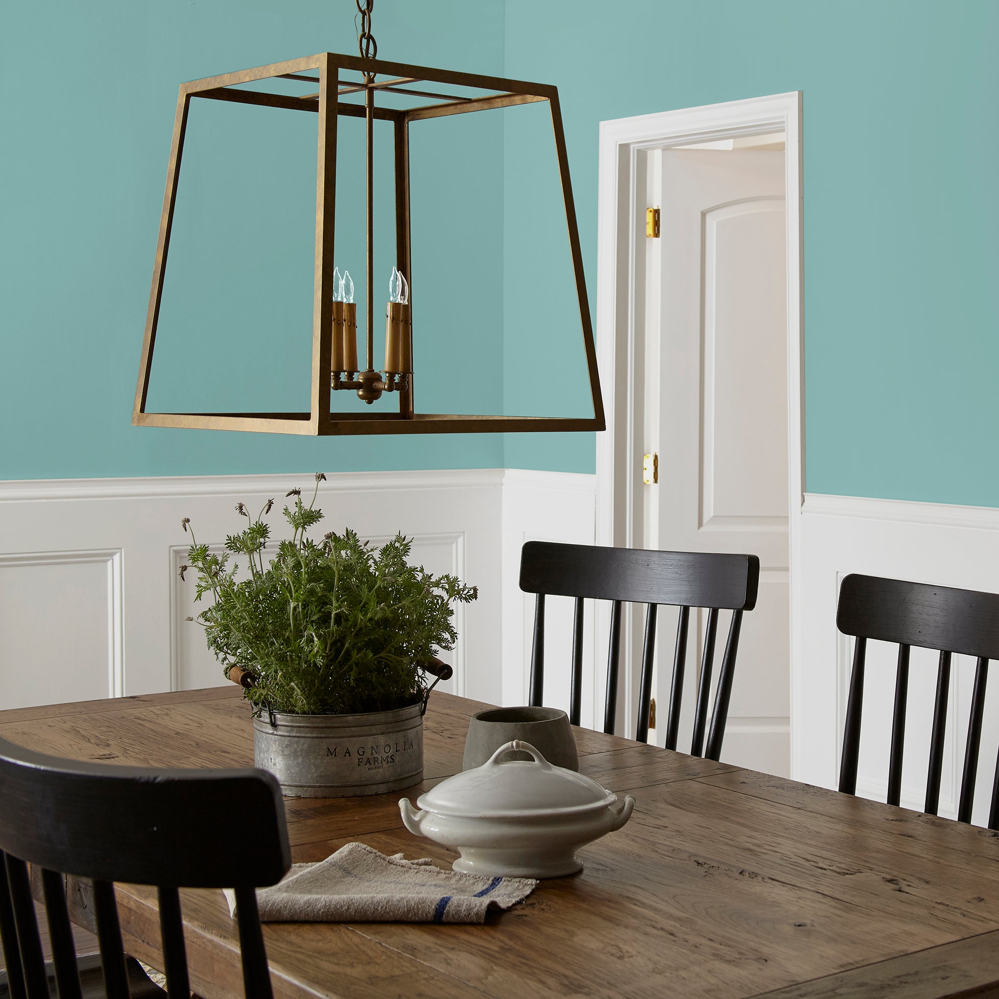 A cool aqua blue interior paint named morning calm shown painted on dining room wall