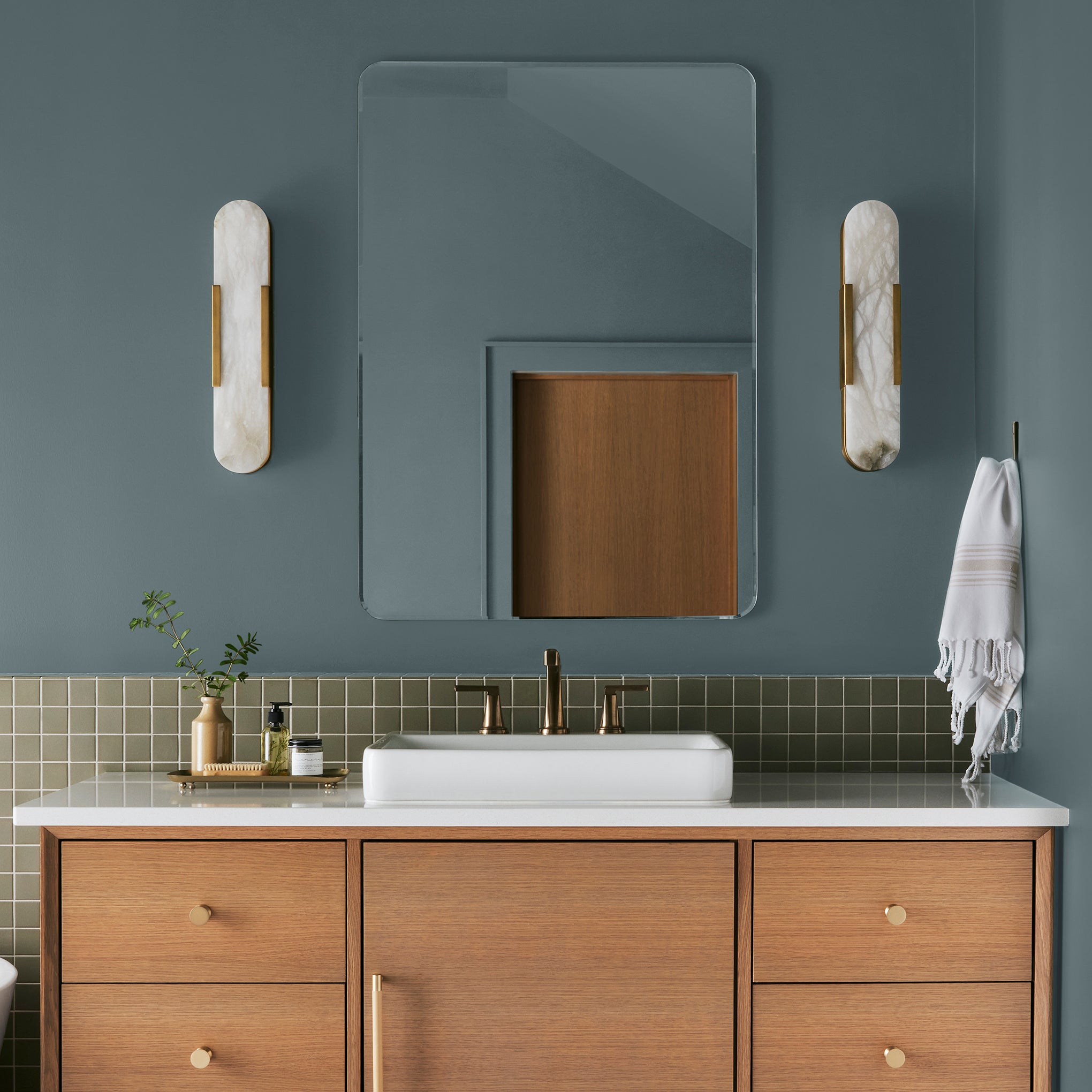A grayed out blue interior paint named storm chaser shown painted on bathroom wall 