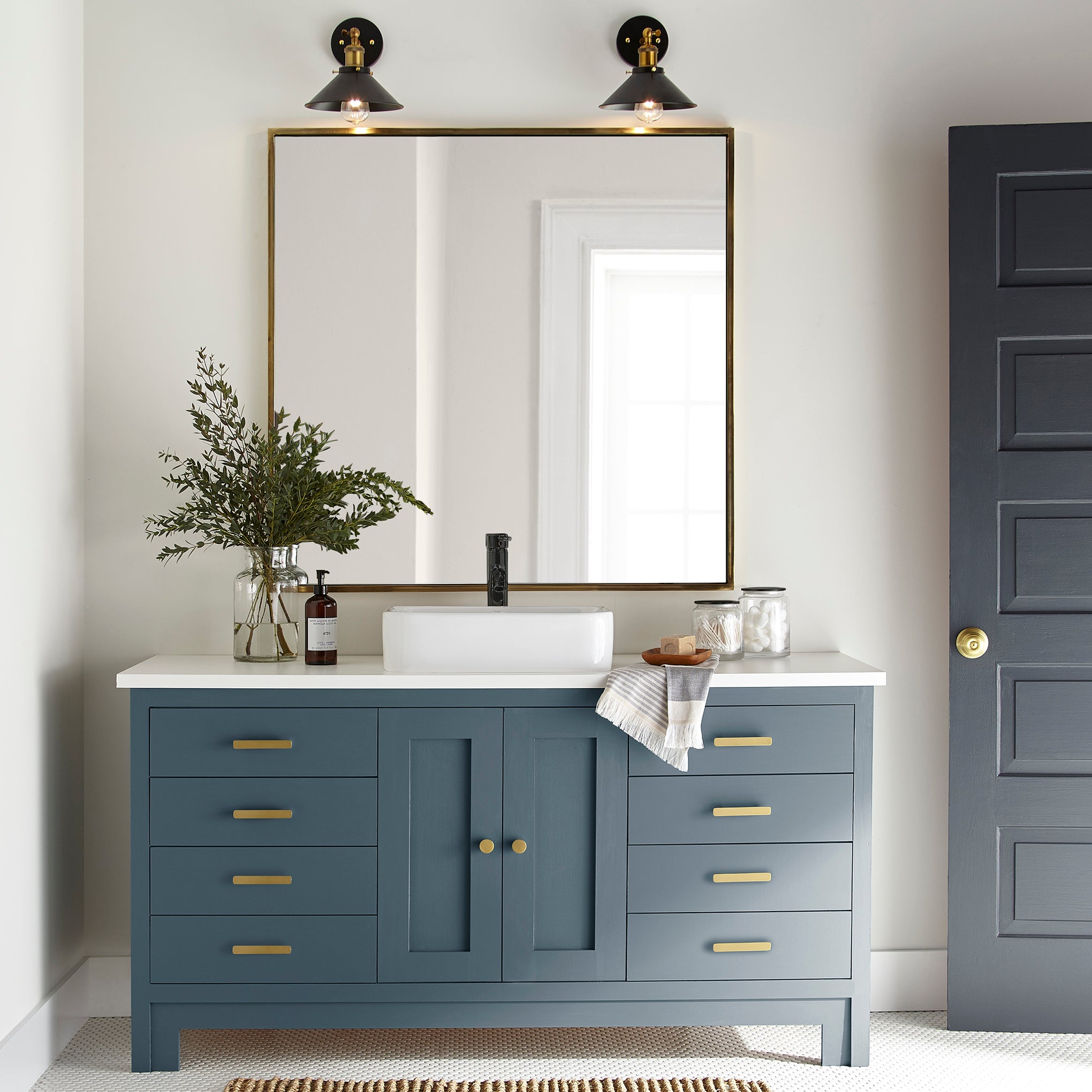 A deep inky blue door and cabinet paint named silos district shown painted on bathroom cabinet