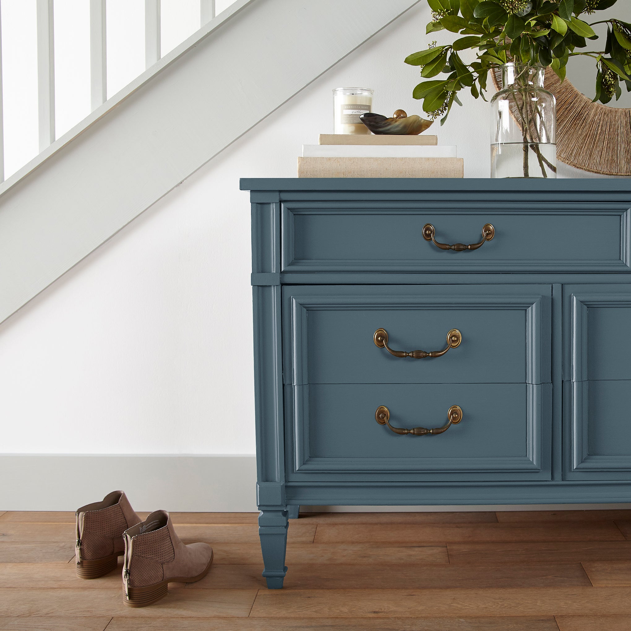 A deep inky blue door and cabinet paint named silos district shown painted on entryway cabinet
