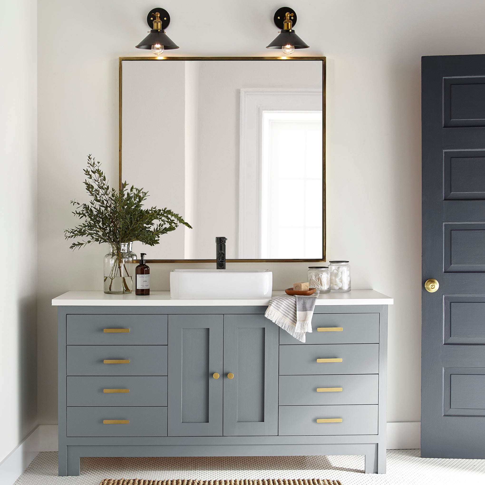 A dark gray with blue undertones door and cabinet paint named deep rock shown painted on bathroom cabinet