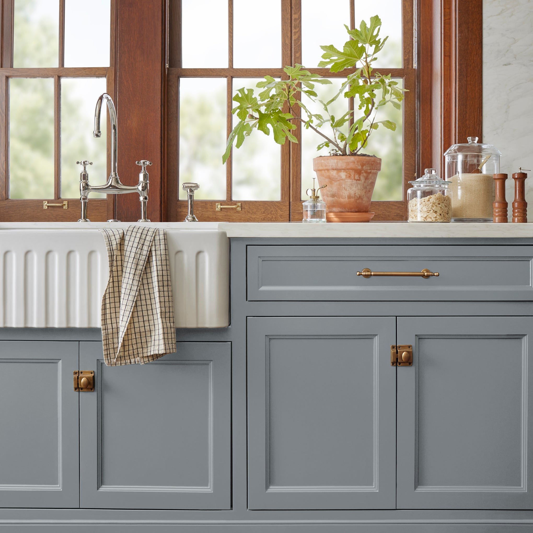 A dark gray with blue undertones door and cabinet paint named deep rock shown painted on kitchen cabinet