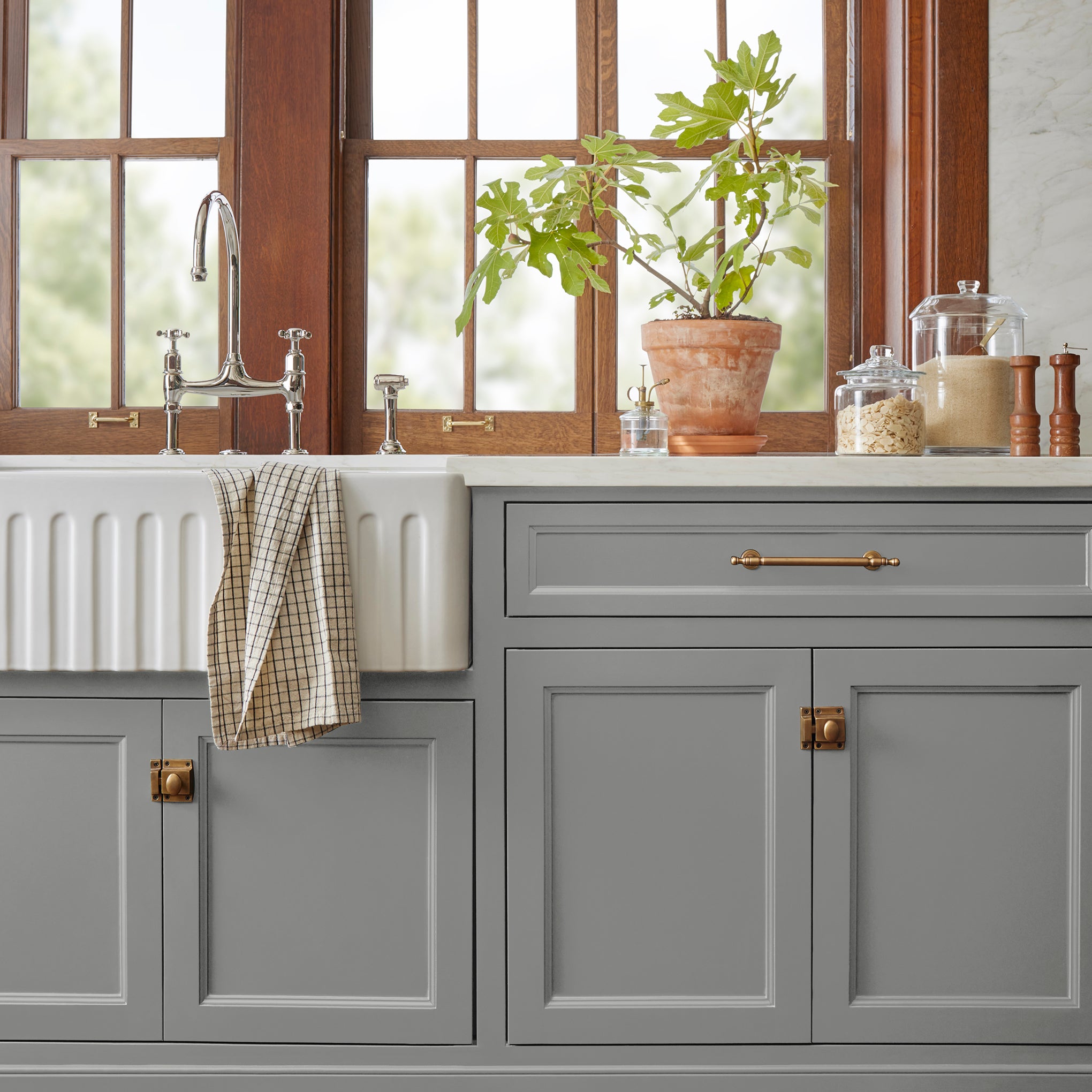 A warm mid-tone gray door and cabinet paint named cozy up shown painted on kitchen cabinet