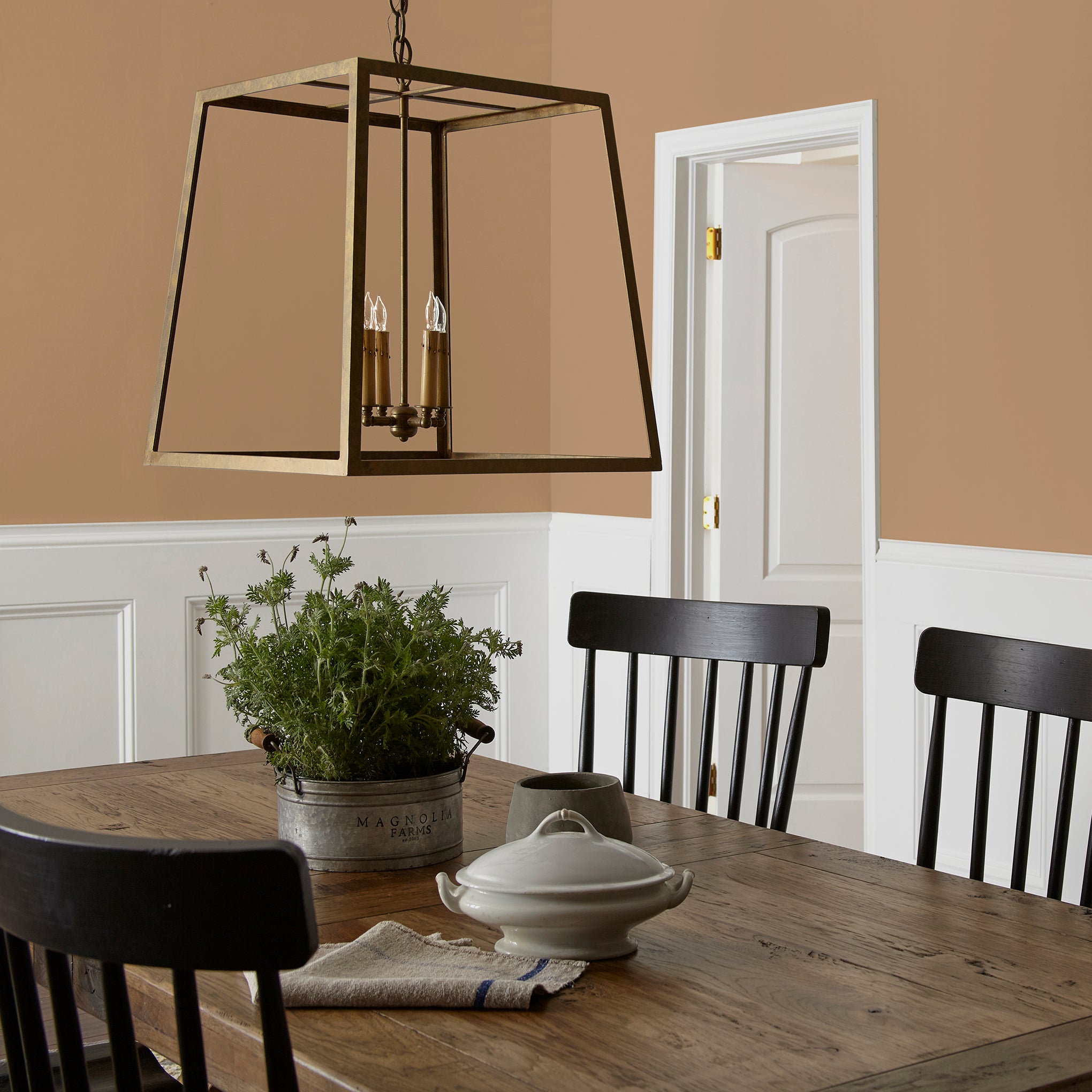 Muted gold interior paint named vintage crown shown painted on dining room wall