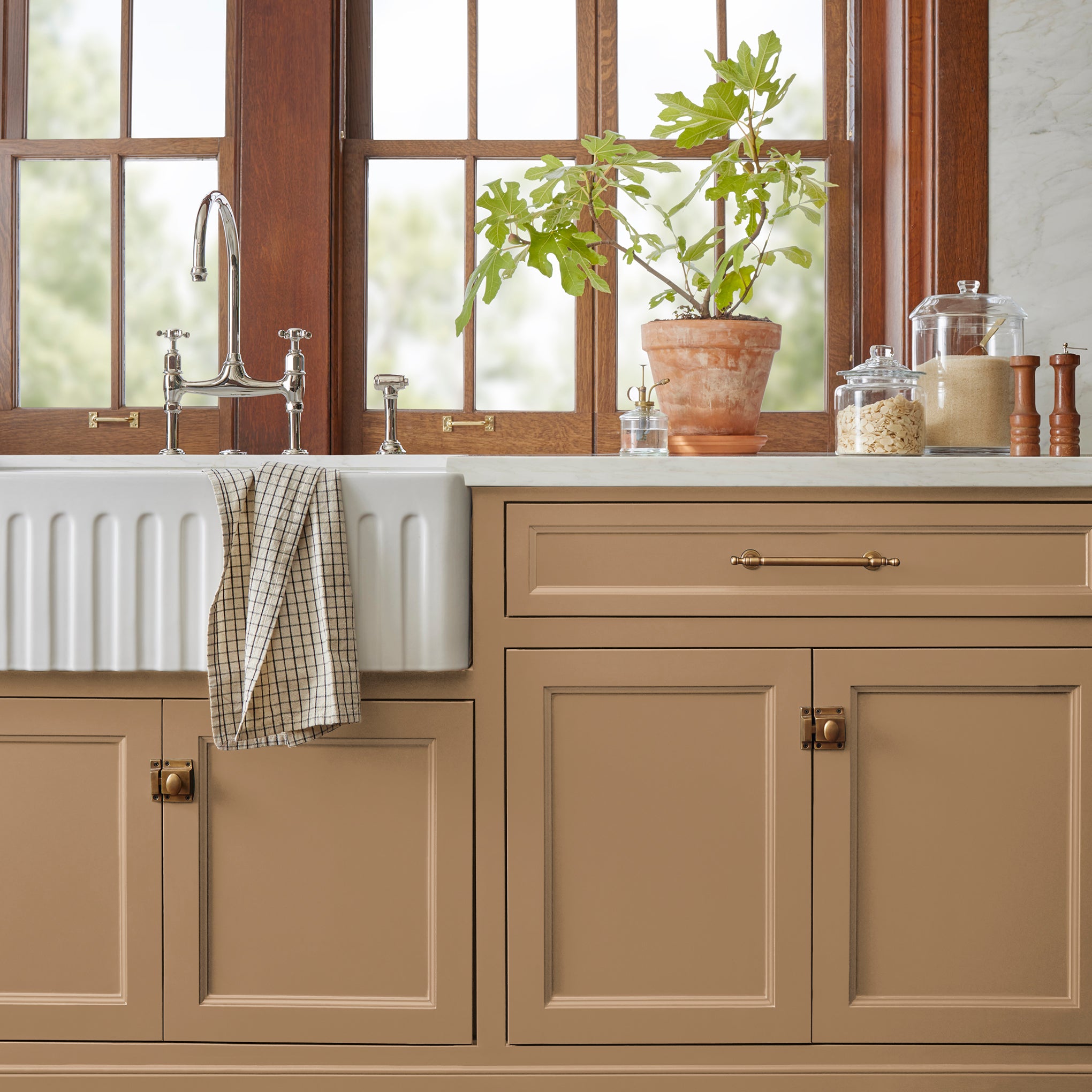 An elegant, muted gold door and cabinet paint named vintage crown shown painted on kitchen cabinet  