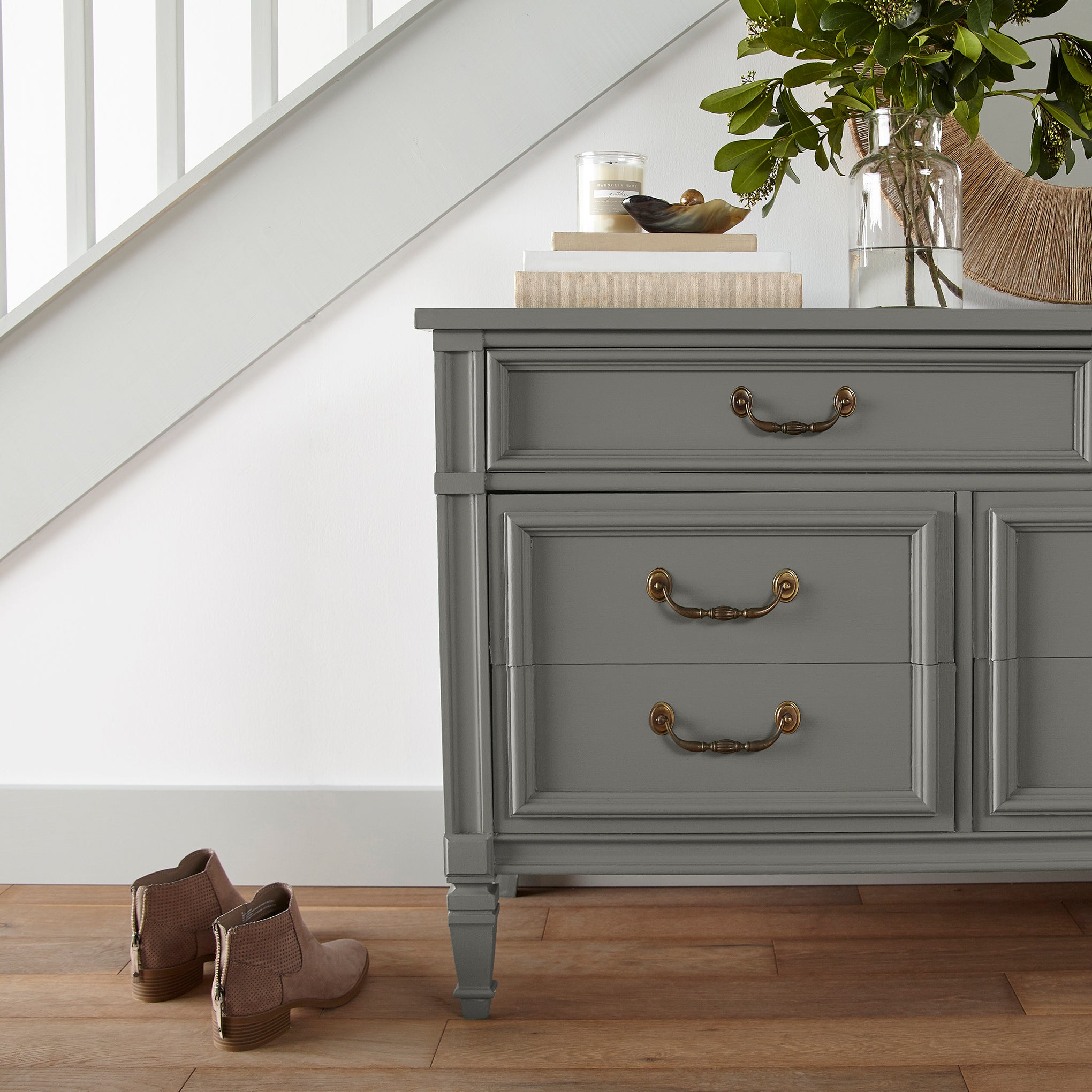 A deep sage with a soft gray undertone door and cabinet paint named estate shown painted on entryway cabinet