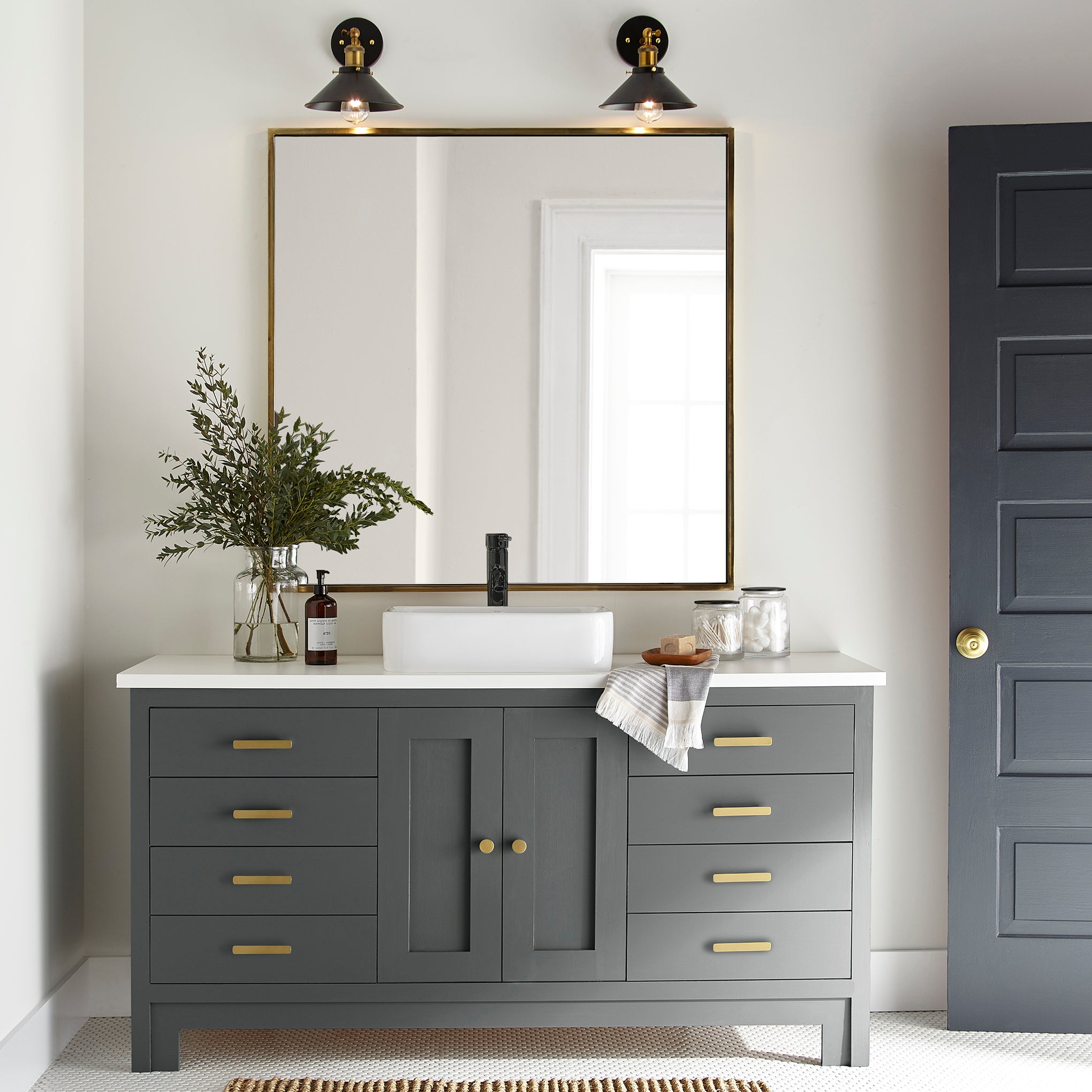 A moody navy infused with a deep green hue door and cabinet paint named cottage grove shown painted on bathroom cabinet