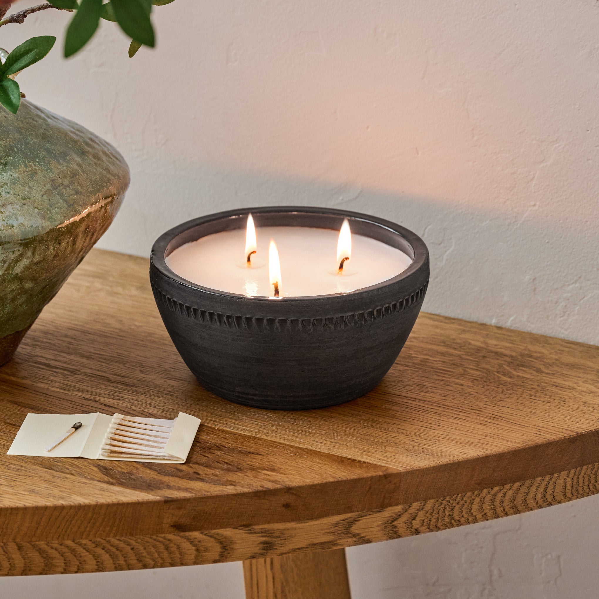 Magnoliass Gathered Rustic Bowl Candle shown burning on table