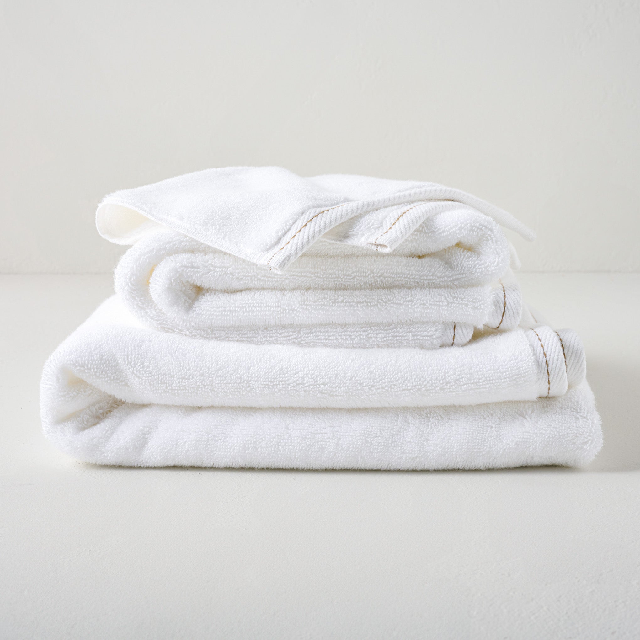 Magnoliass White Plush Stitched Edge Towels shown stacked