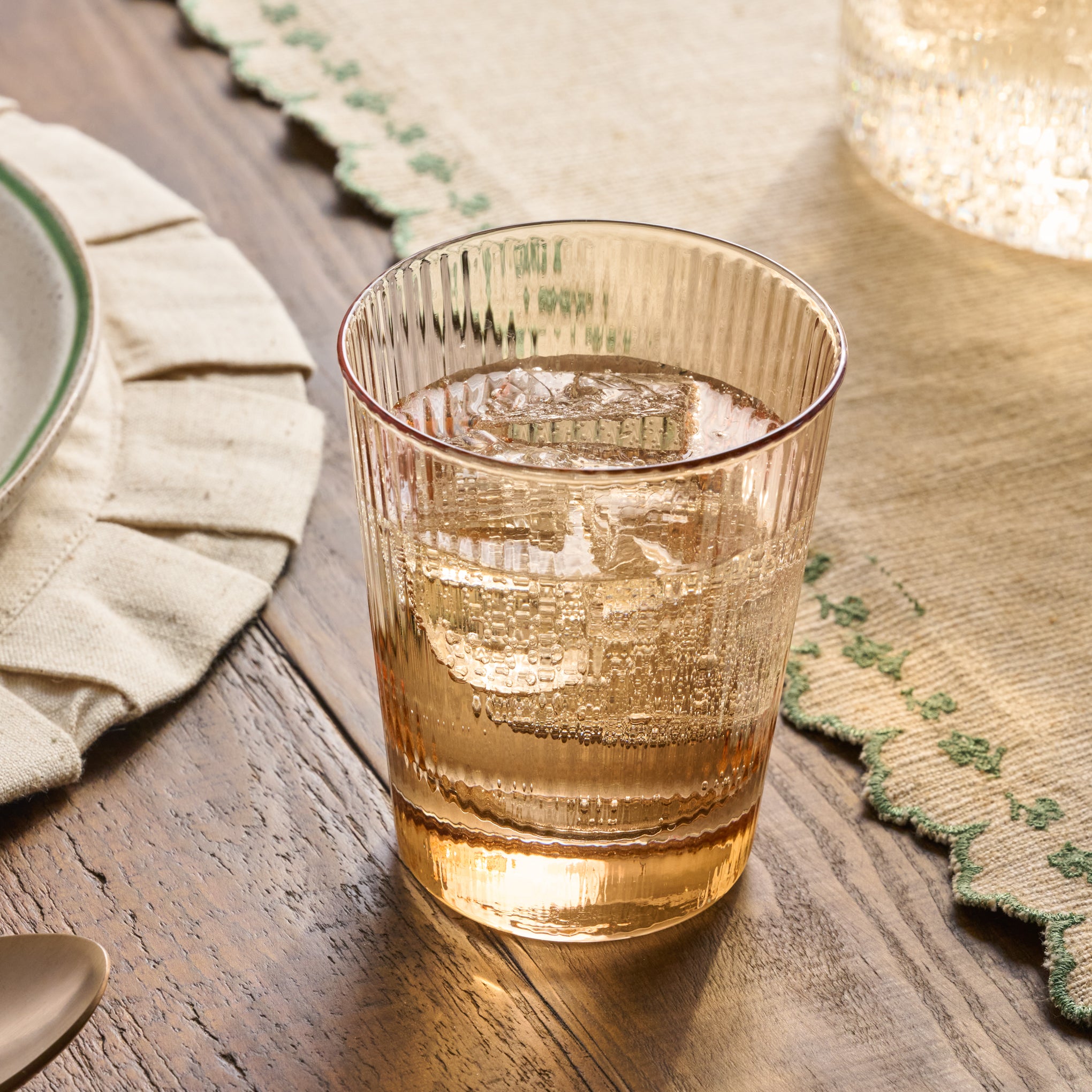 Peach Ribbed Glass Tumbler shown on table filled with water