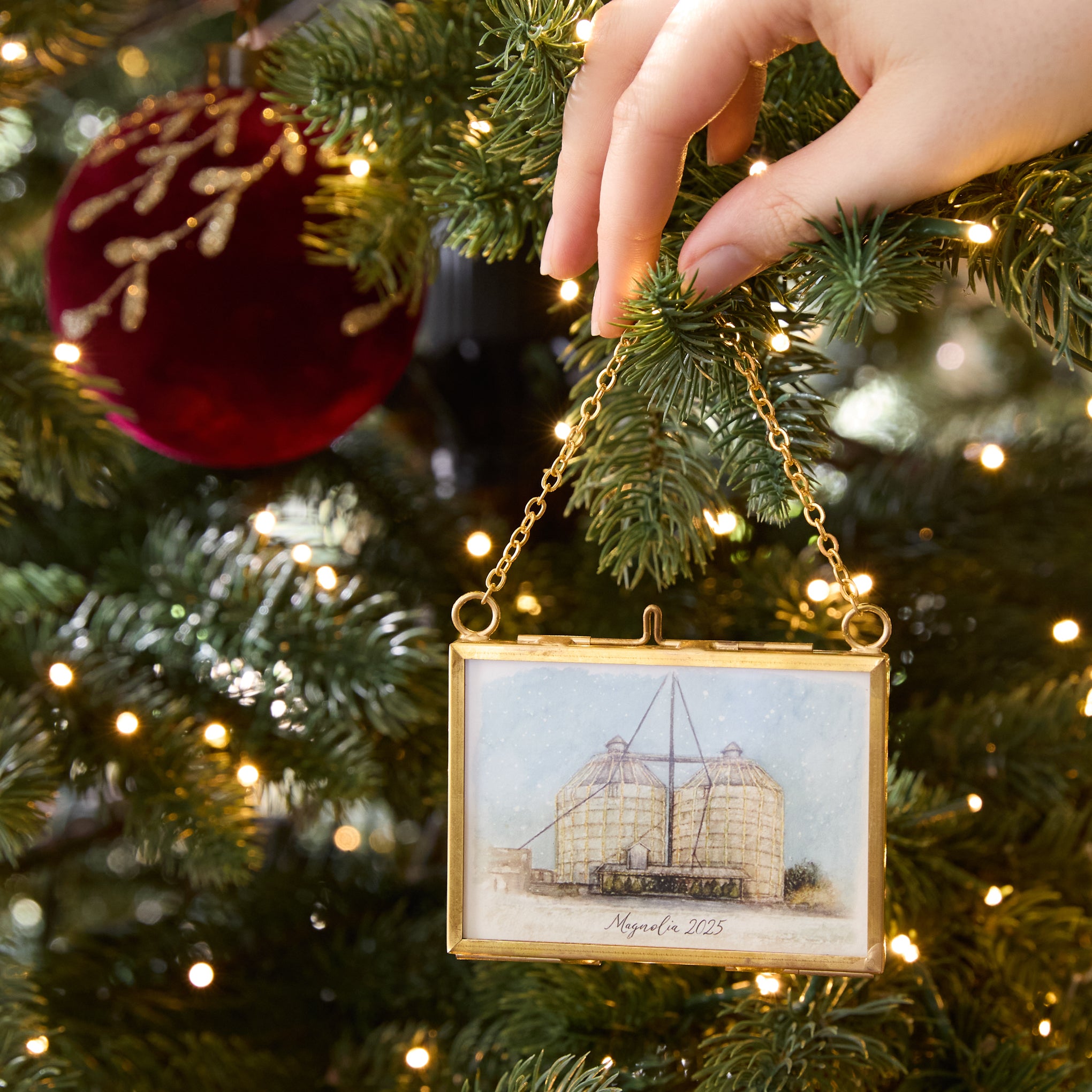 Magnoliass 2025 Limited Edition Mini Framed Ornament by Tabitha Paige being hung on a tree