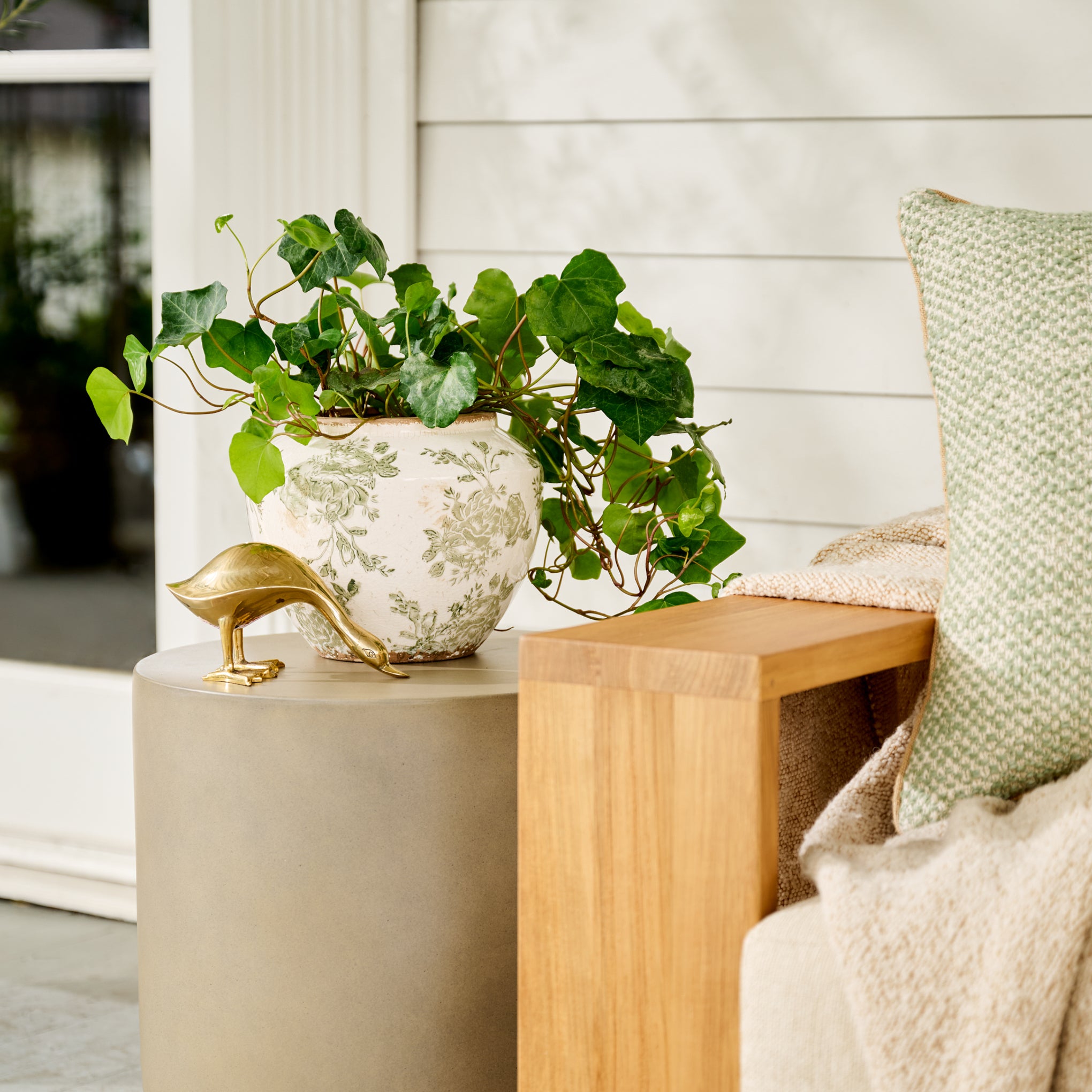 Small Green and White Distressed Floral Vase shown outside