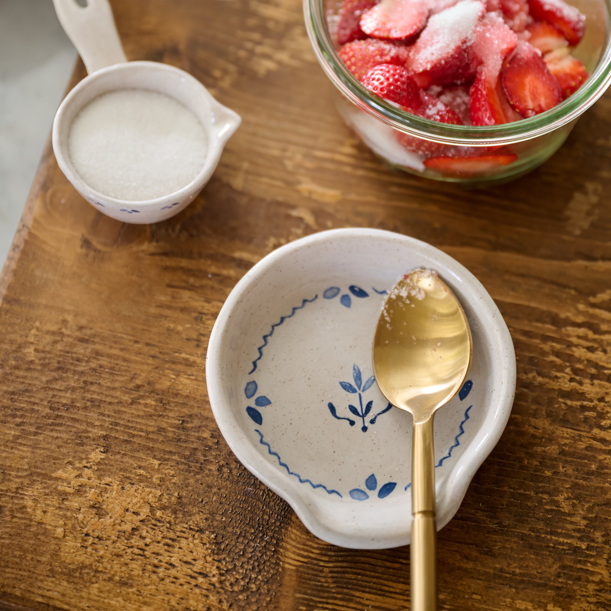 Juliet Ceramic Spoon Rest on cutting board with gold silverware